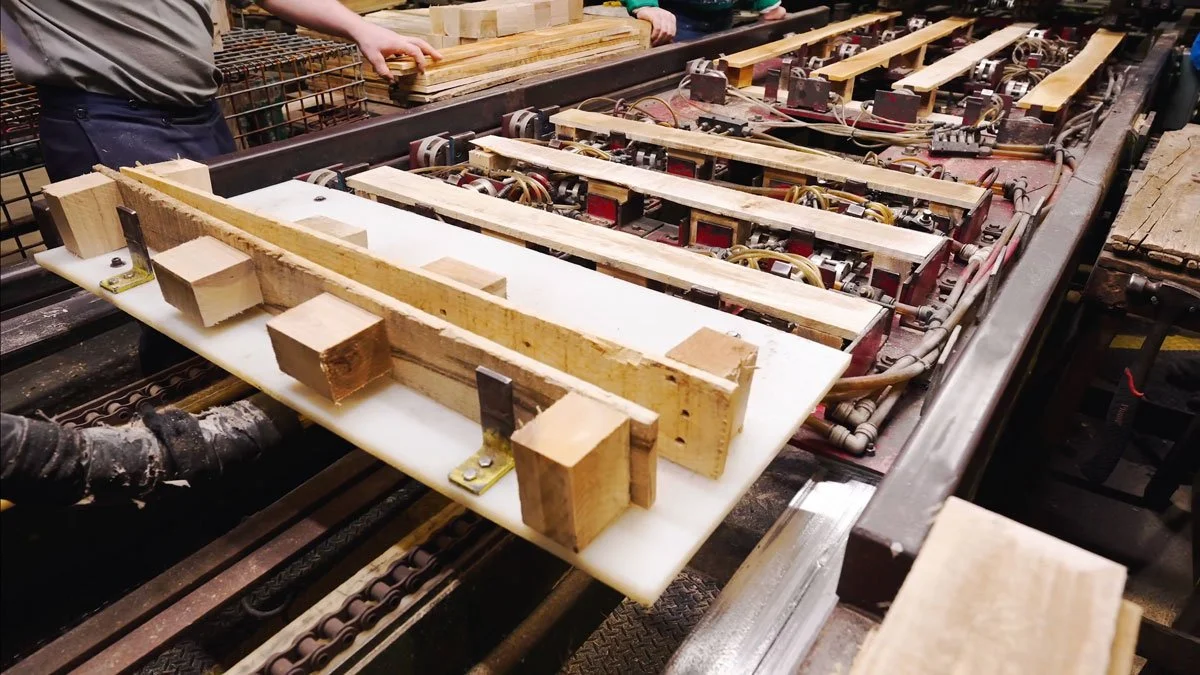 machine and workers making block wood pallets