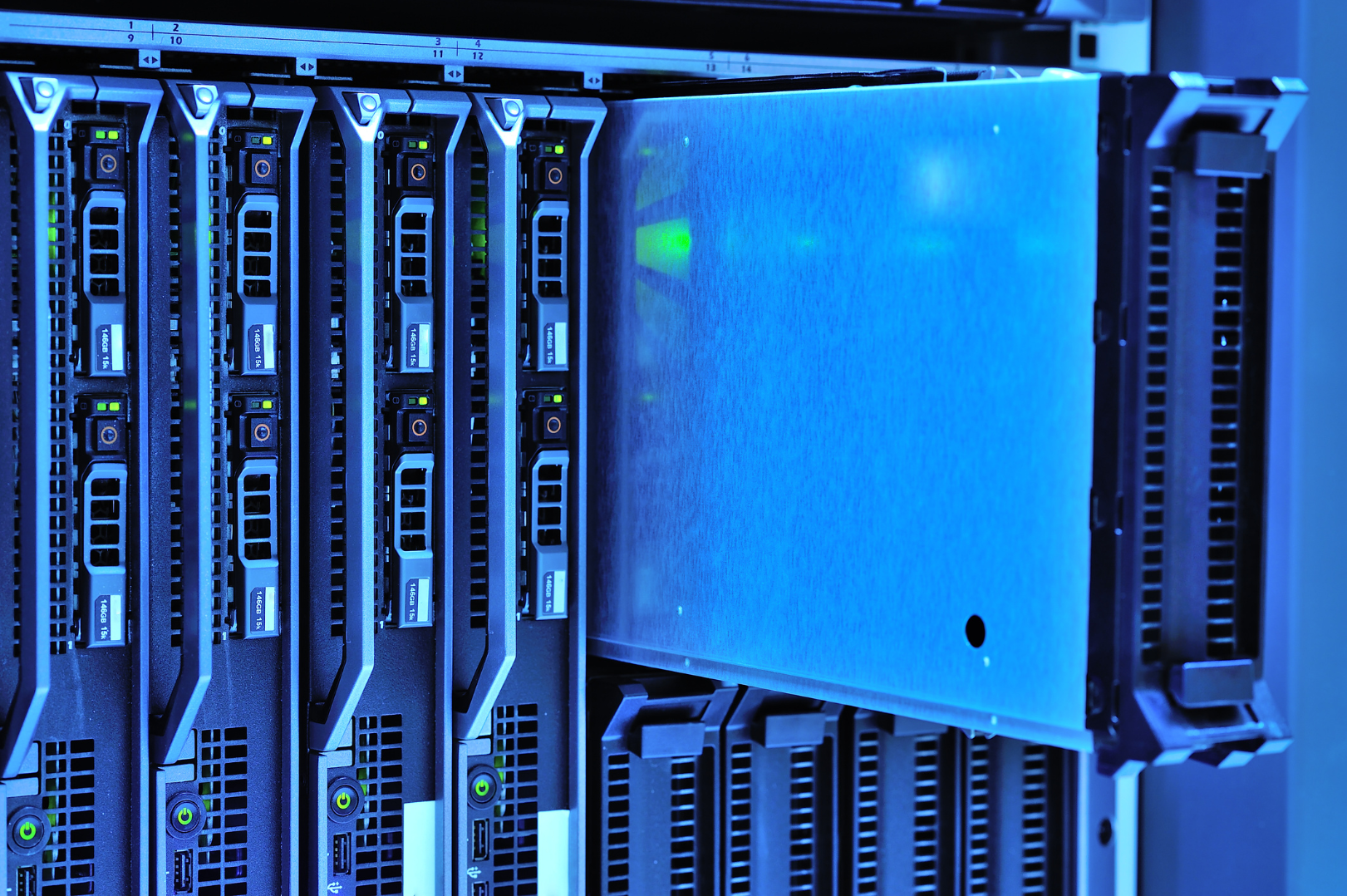Close-up of a server rack with multiple high-performance computer servers illuminated by blue LED lights.