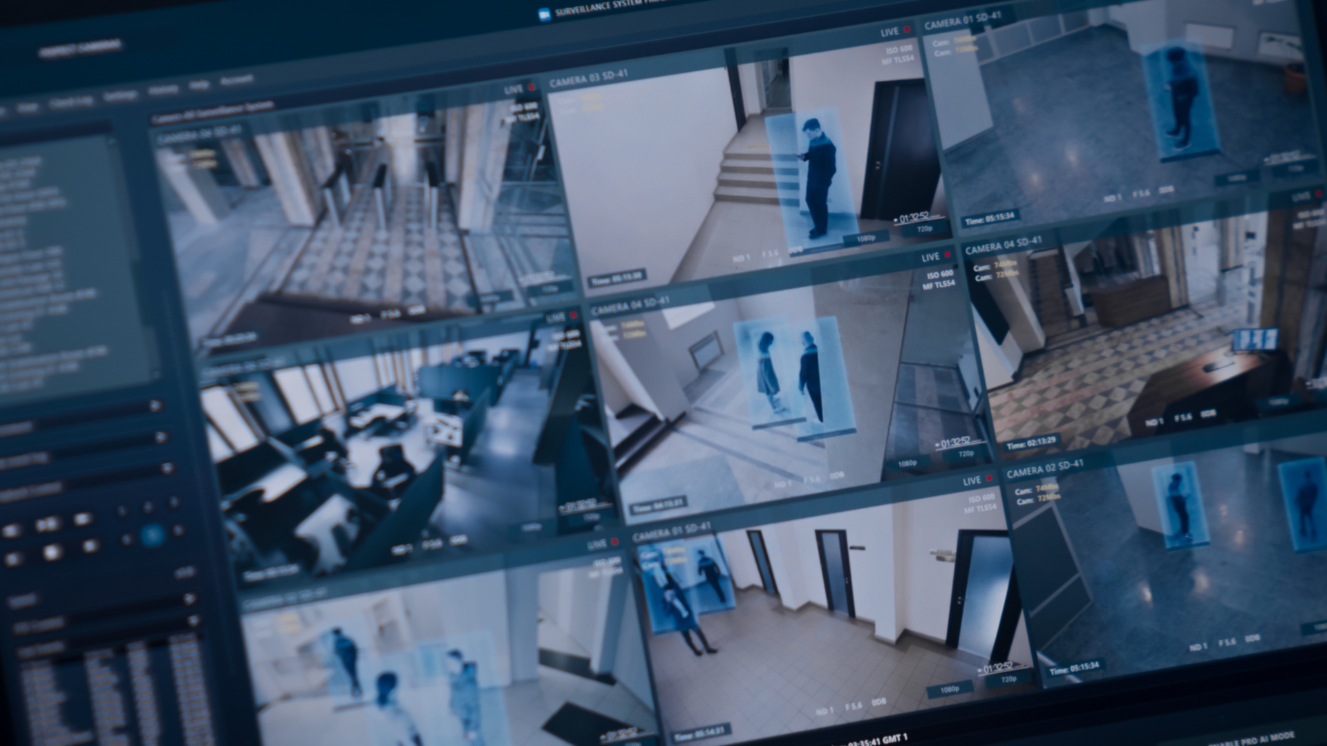 Multiple surveillance camera feeds displayed on a security monitoring screen, showing various indoor scenes with people and architectural details.