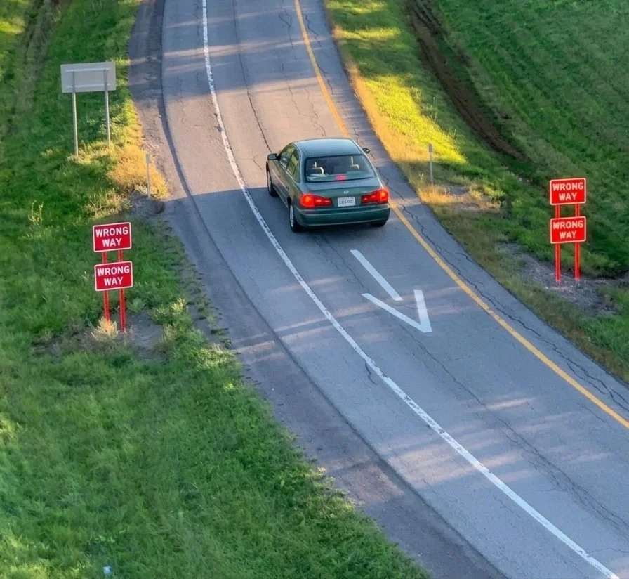 A car going the wrong way on a highway entrance ramp.