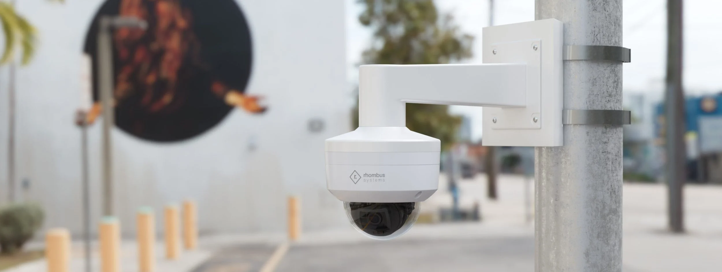 Close-up of a white security camera mounted on a metal pole