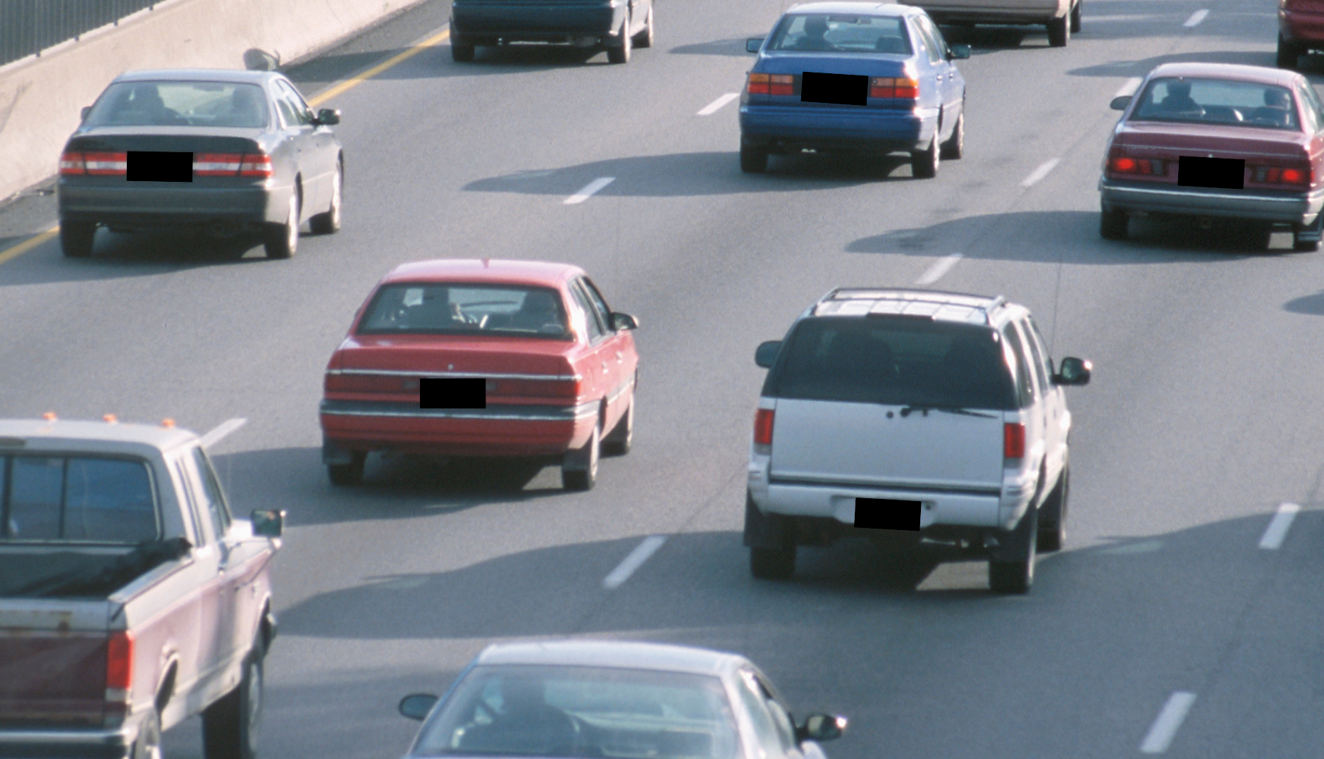 Multiple cars on a multi-lane highway, with some cars visibly traveling and some merging or changing lanes.