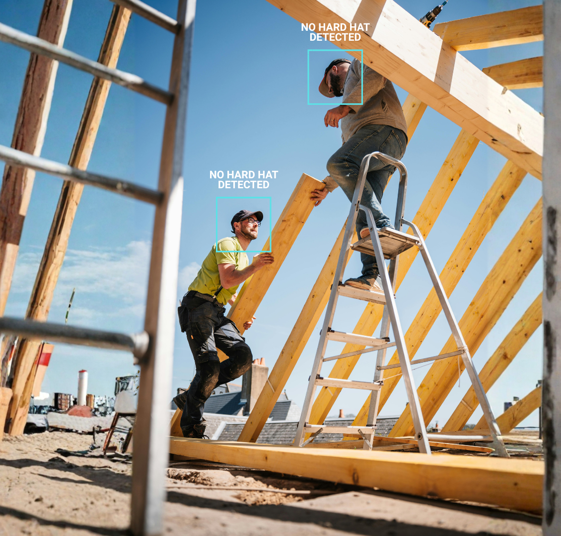 Two construction workers building a wooden frame for a roof on a clear day, with one worker standing on a ladder and the other helping him hold a piece of wood. No hard hats detected.