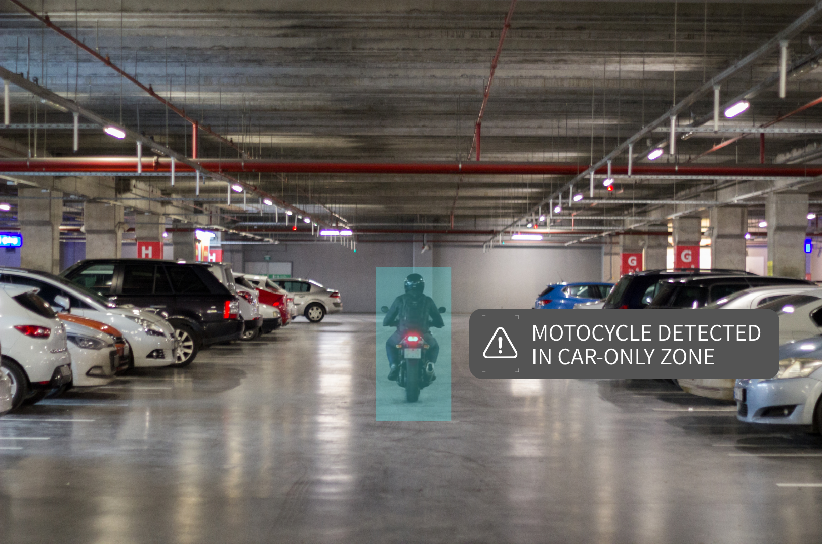 Underground parking garage with several parked cars and a motorcyclist in a designated car-only zone, with a warning sign indicating motorcycle detection in the area.