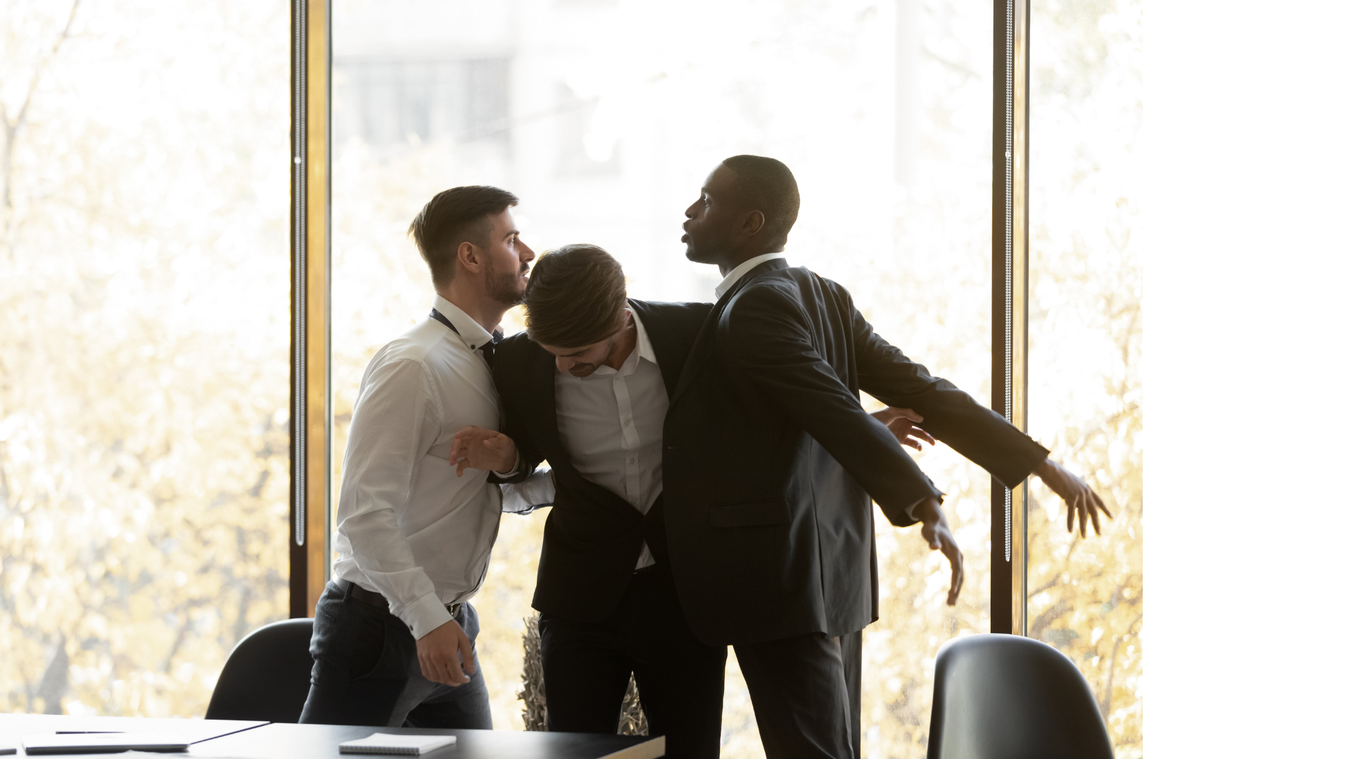 Three men in professional attire engaged in a physical argument or confrontation in a modern office with large windows showing autumn trees outside.