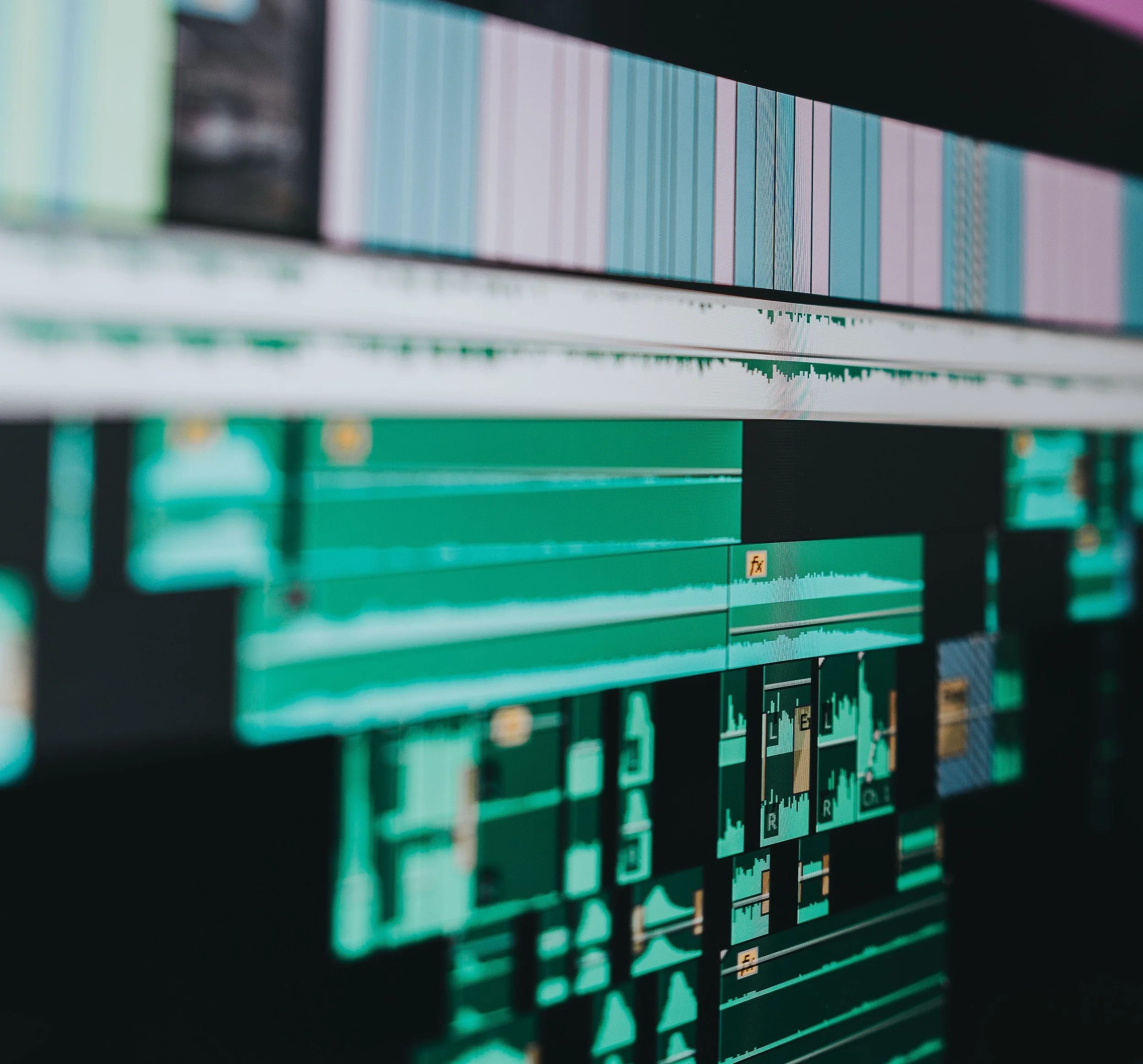 Close-up of computer screen displaying digital audio editing software with waveforms and tracks.
