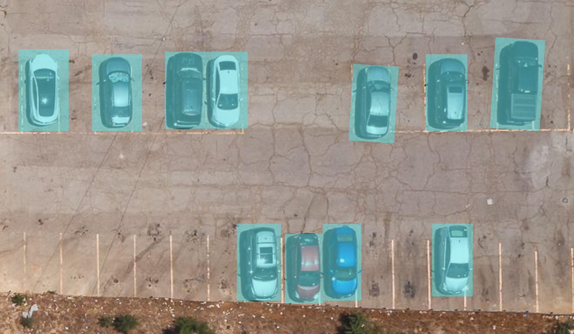 Cars parked in a parking lot with a blue outline indicating vehicle detection.