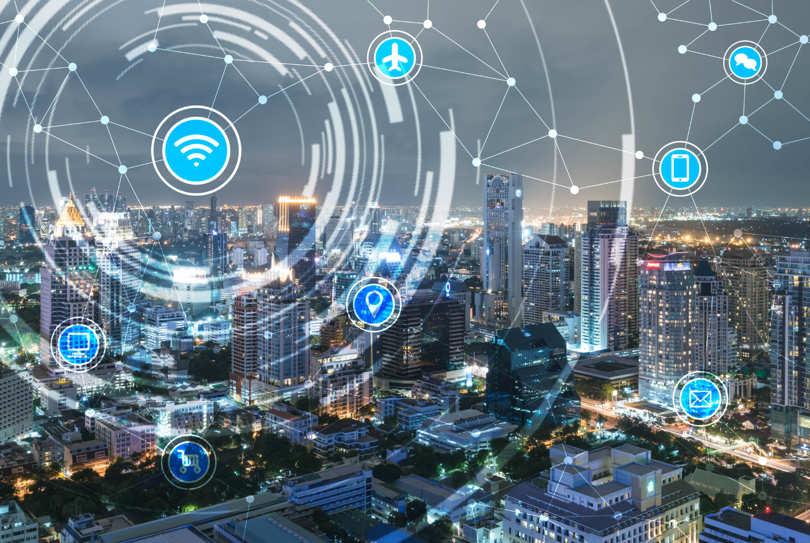 A city skyline at night with digital icons representing connectivity, Wi-Fi, location, email, and transportation overlaid, symbolizing smart city technology and internet connectivity.