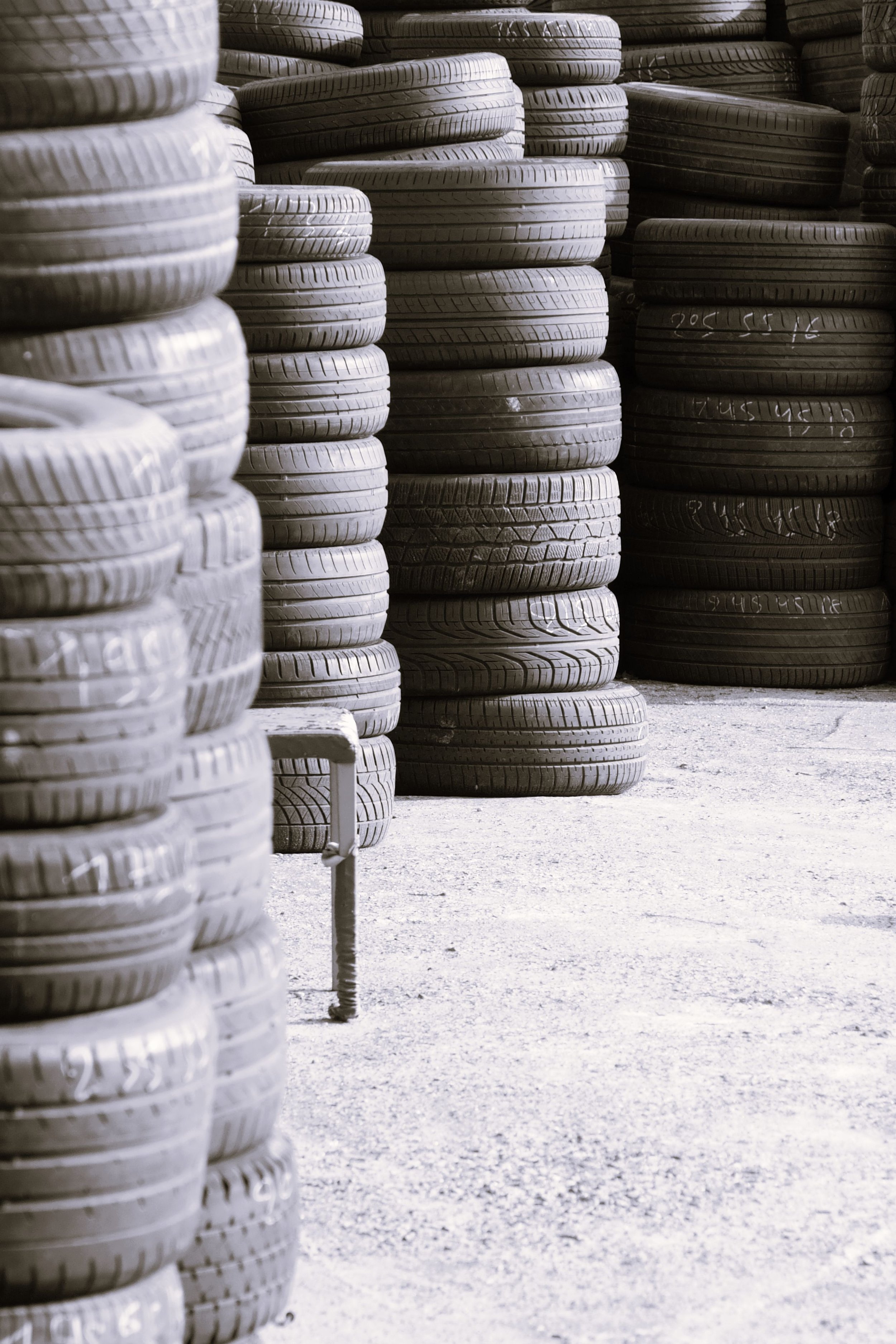 Stacks of tires stored outdoors at a tire shop.