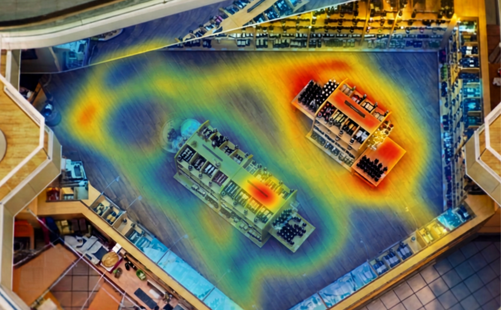 A retail store interior with surrounding shelves stocked with various products. The floor has a heatmap overlay indicating movement or activity levels, with the highest activity in the center near the shelves and lower activity along the outer edges.
