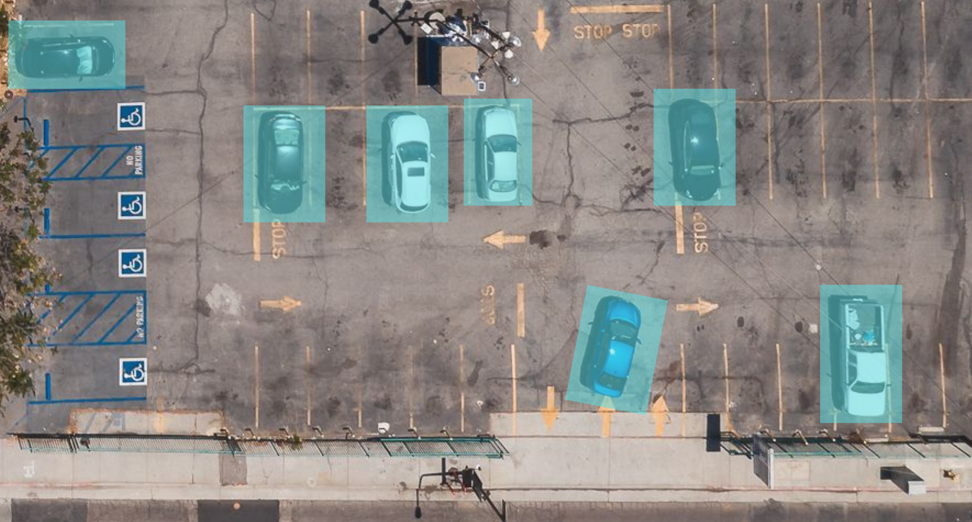 An aerial view of a parking lot with seven cars parked, highlighted in light blue boxed showcasing the vehicle counting feature.