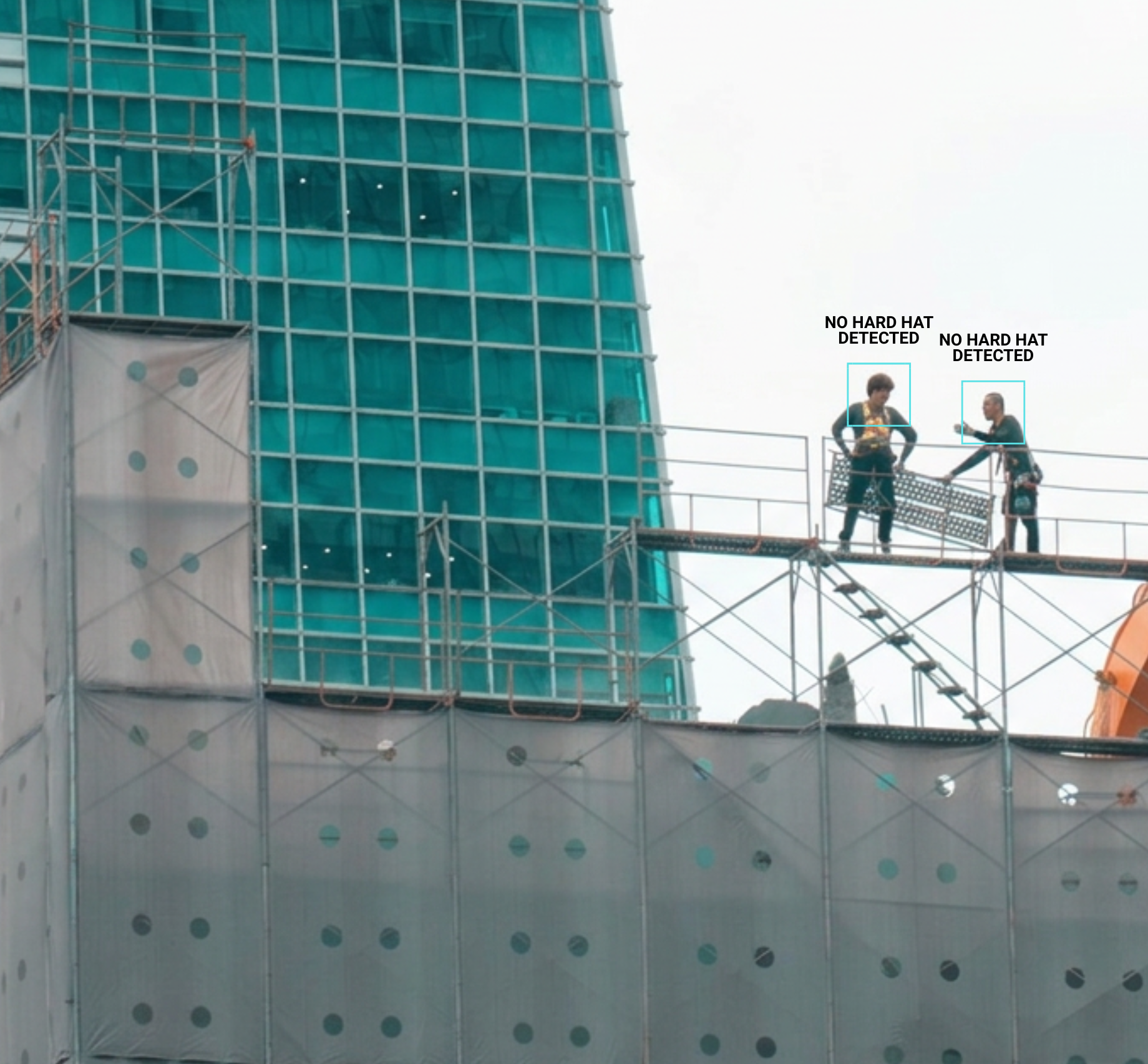 Two construction workers on scaffolding in front of a partially built glass building, with signs above their heads that read 'NO HARD HAT DETECTED.'