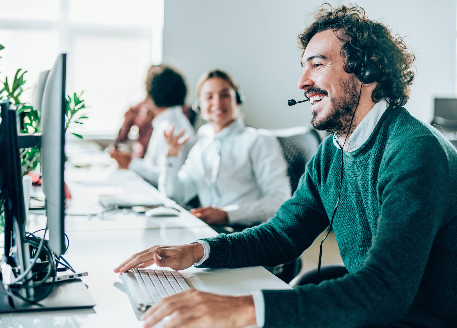 Customer service representatives working at computers in call center environment.