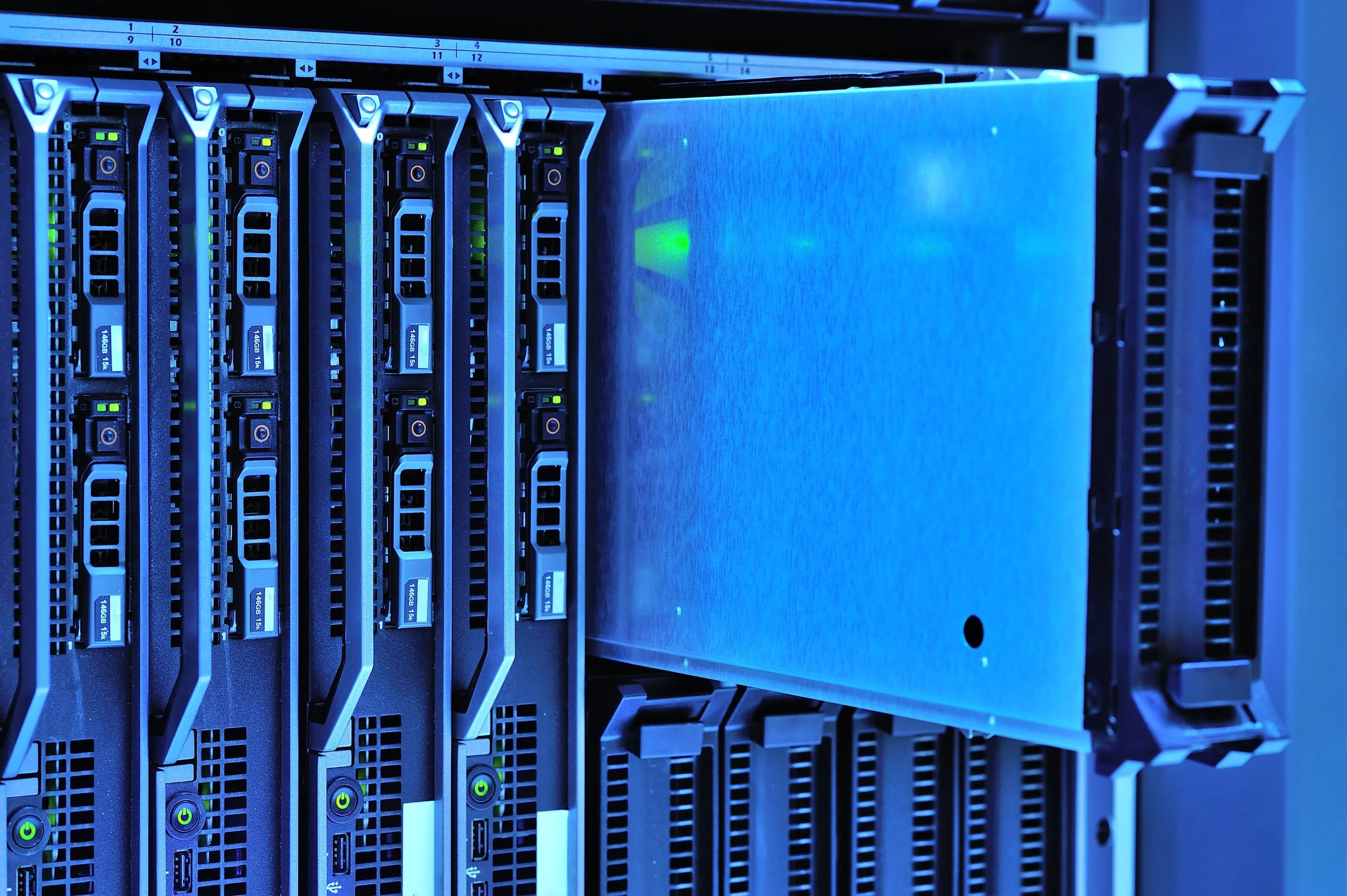Close-up of a server rack with multiple green-lit server units with blue and black components.
