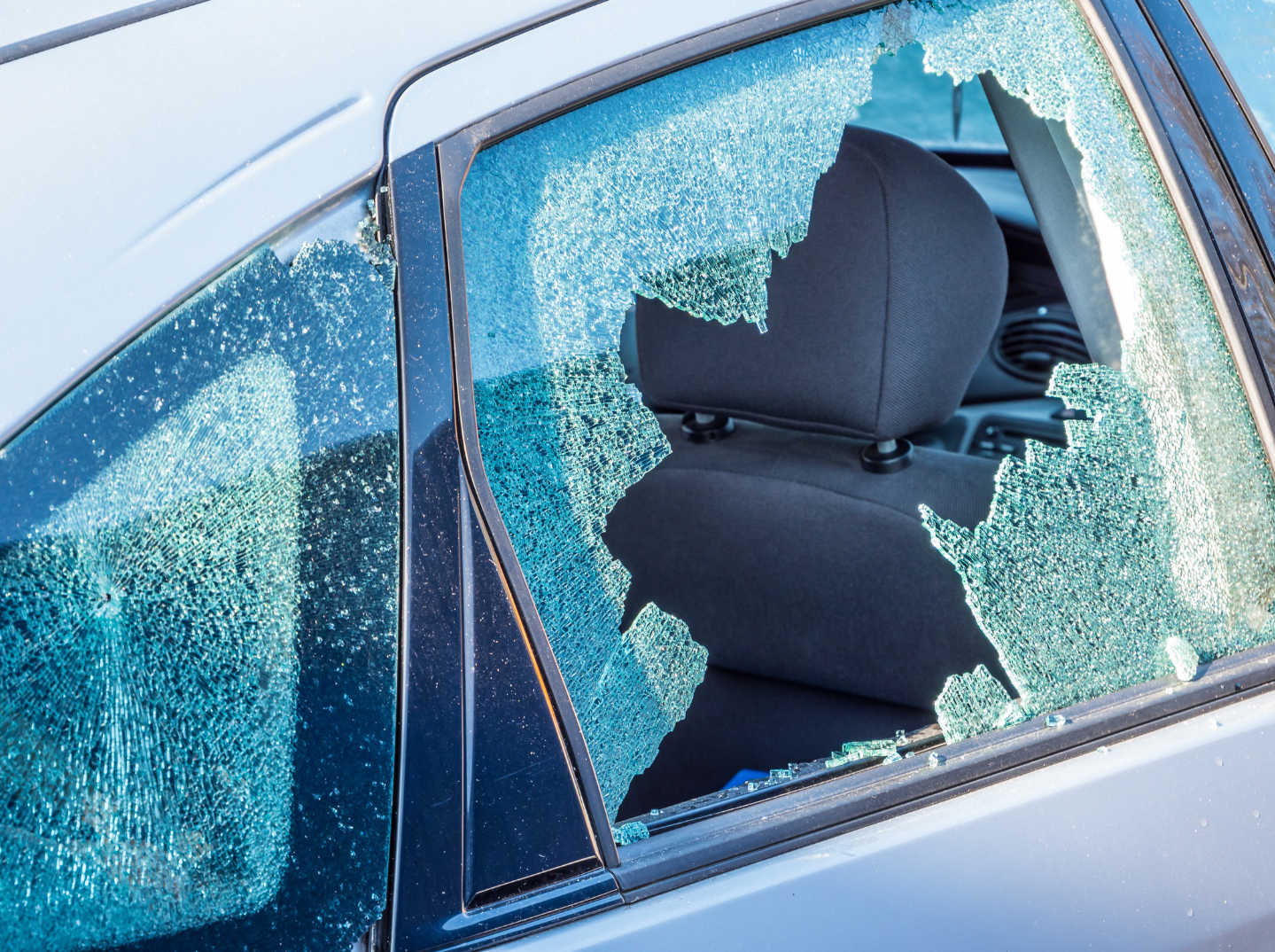 A car with a shattered rear passenger window.