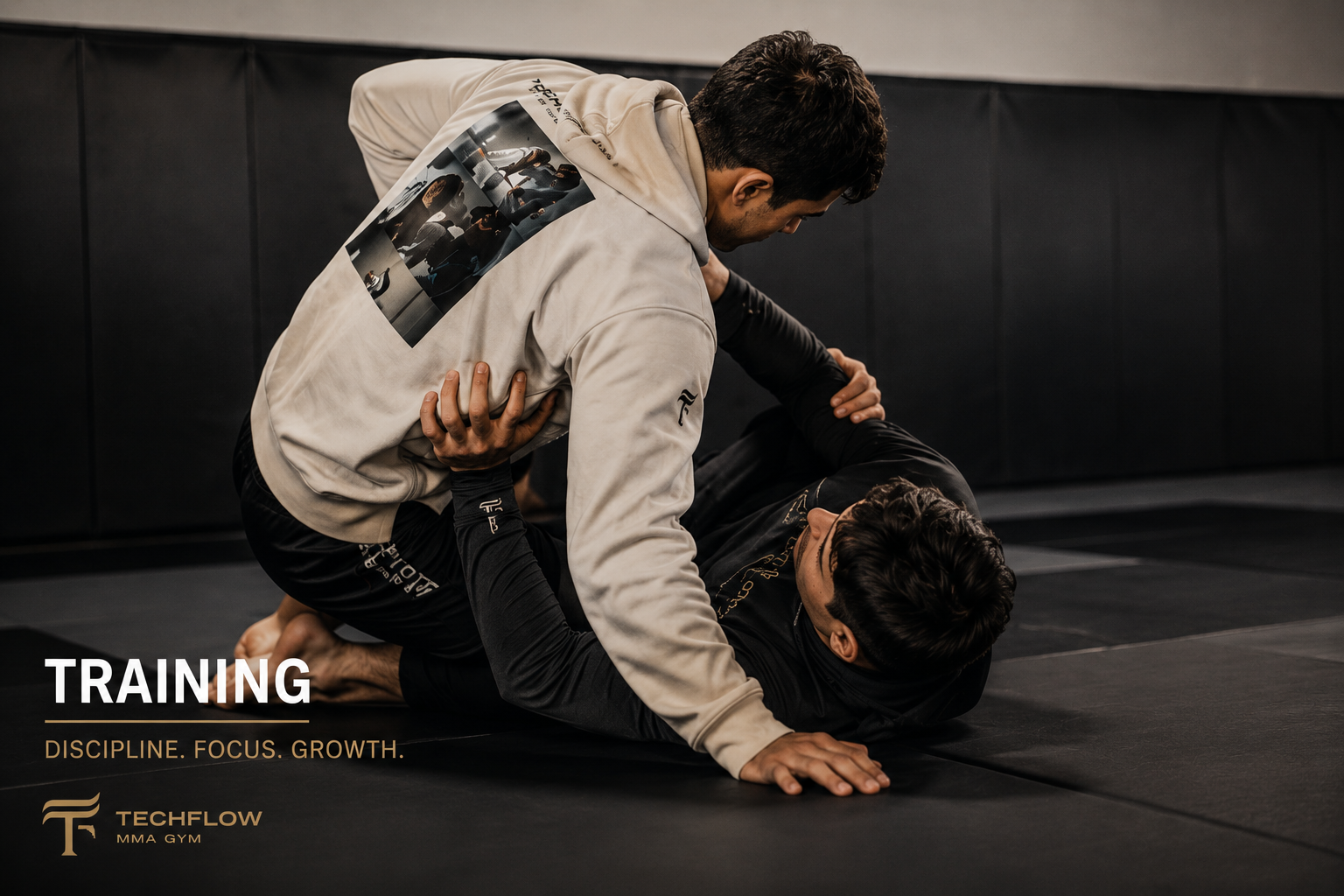 Two men practicing Brazilian Jiu-Jitsu on a black mat in a gym. One man is in a top position, controlling the other who is on the ground. The gym has padded walls and a logo that reads "TECHFLOW MMA GYM." Text on the image says "TRAINING. DISCIPLINE. FOCUS. GROWTH."