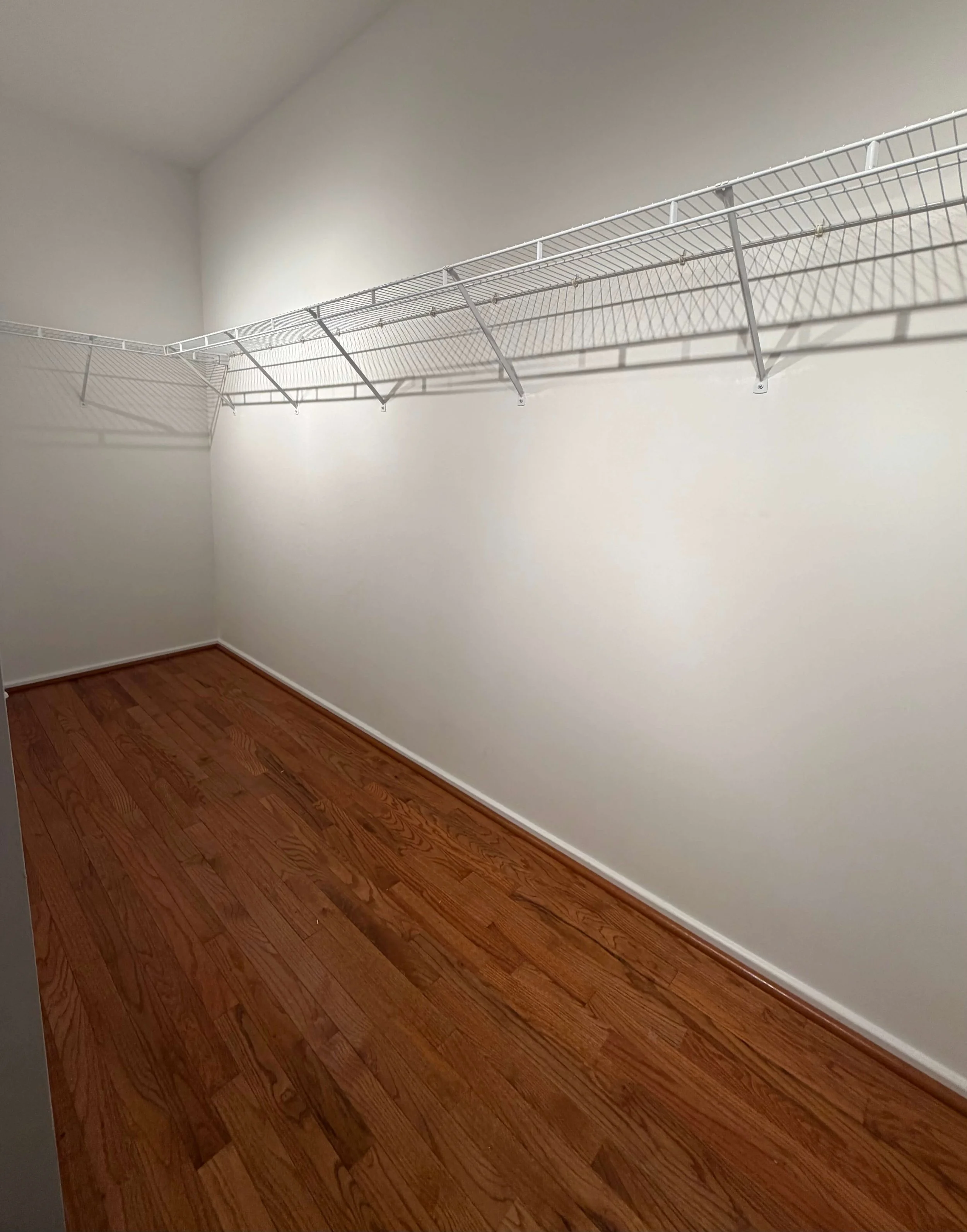 Closet in oak park with white, metal builder grade shelving