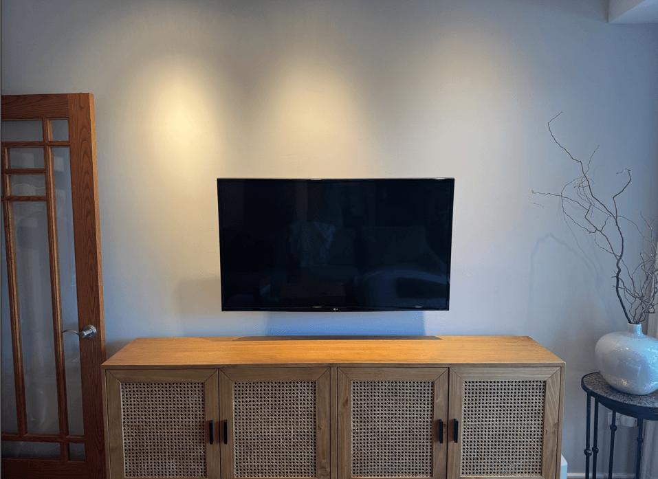 TV mounted by handyman in Oak Park living room above entertainment center with cords hidden