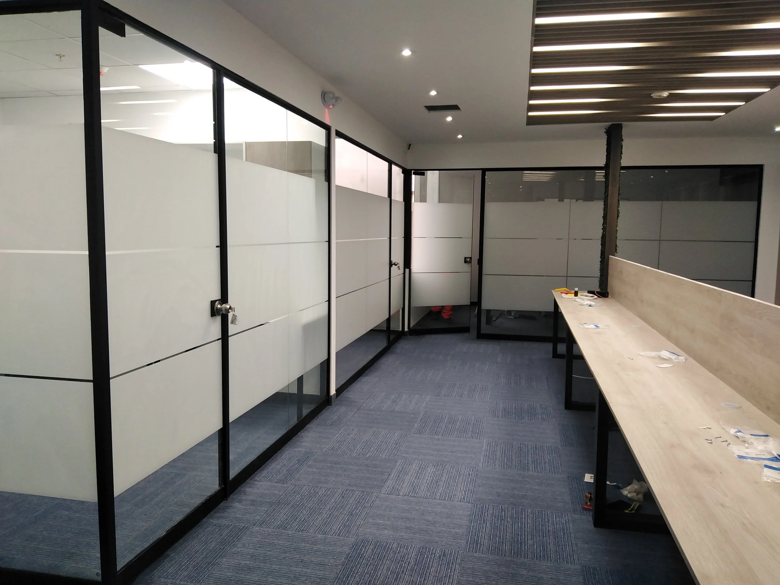 Oficinas  con divisiones de vidrio templado de 8mm. y laminas arenadas, mesa de trabajo de melamine .Obra realizada en miraflores
