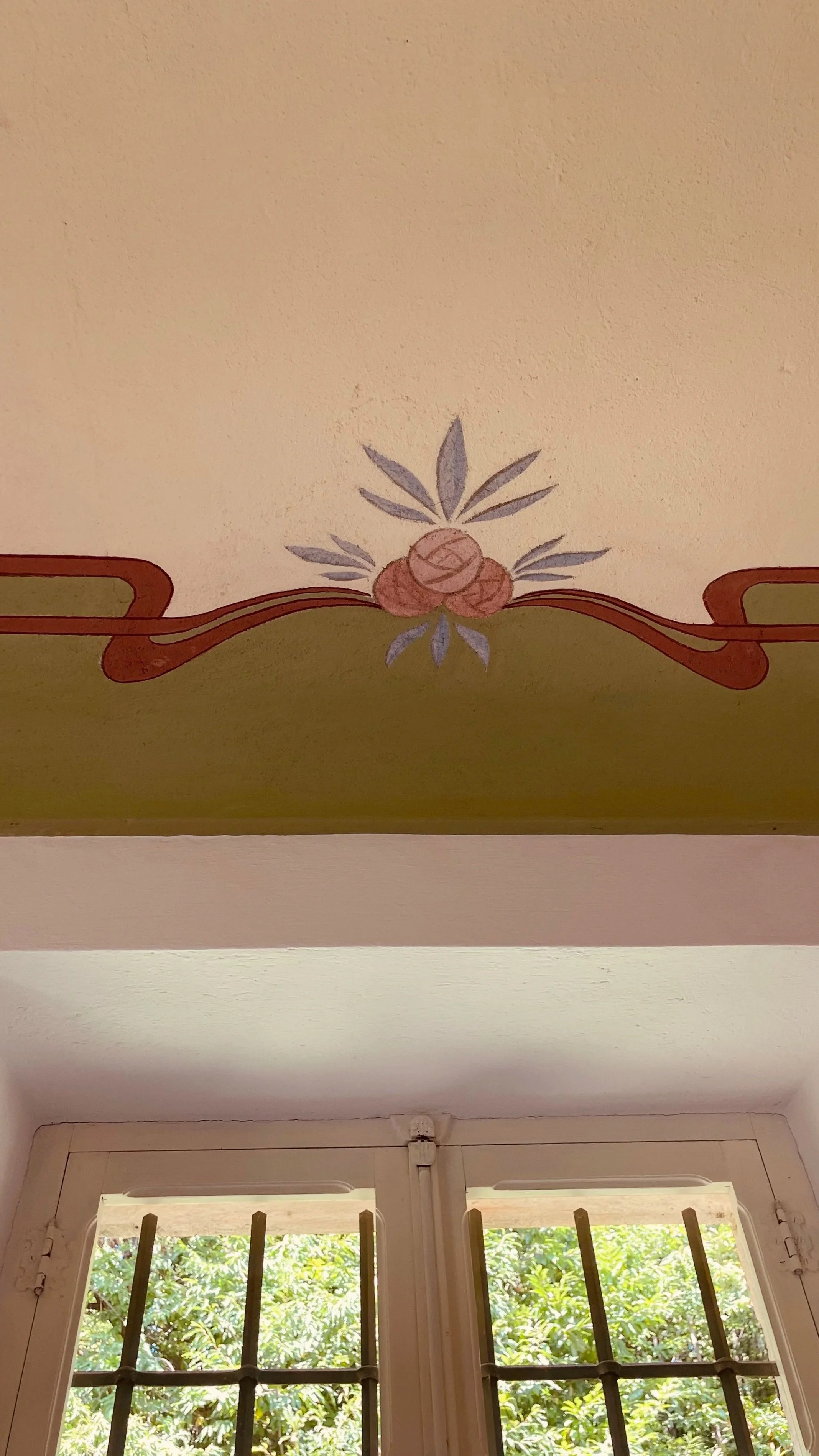 Original floral fresco above a garden window at Villa Oberti, a carefully restored 1912 villa in Piedmont
