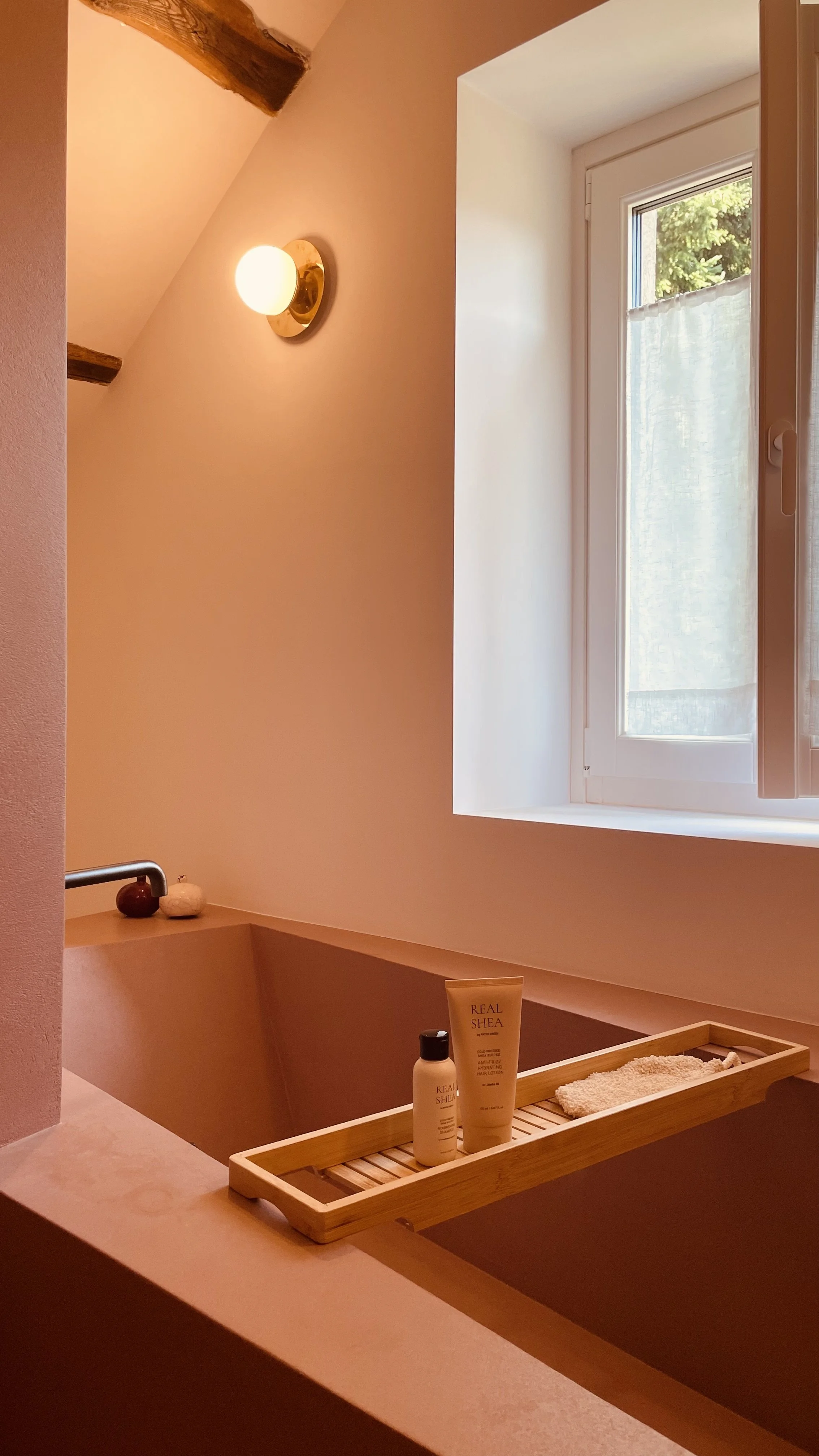 Terracotta bathtub by the window in the Cielo Suite at Villa Oberti, a charming countryside villa near Mondovì