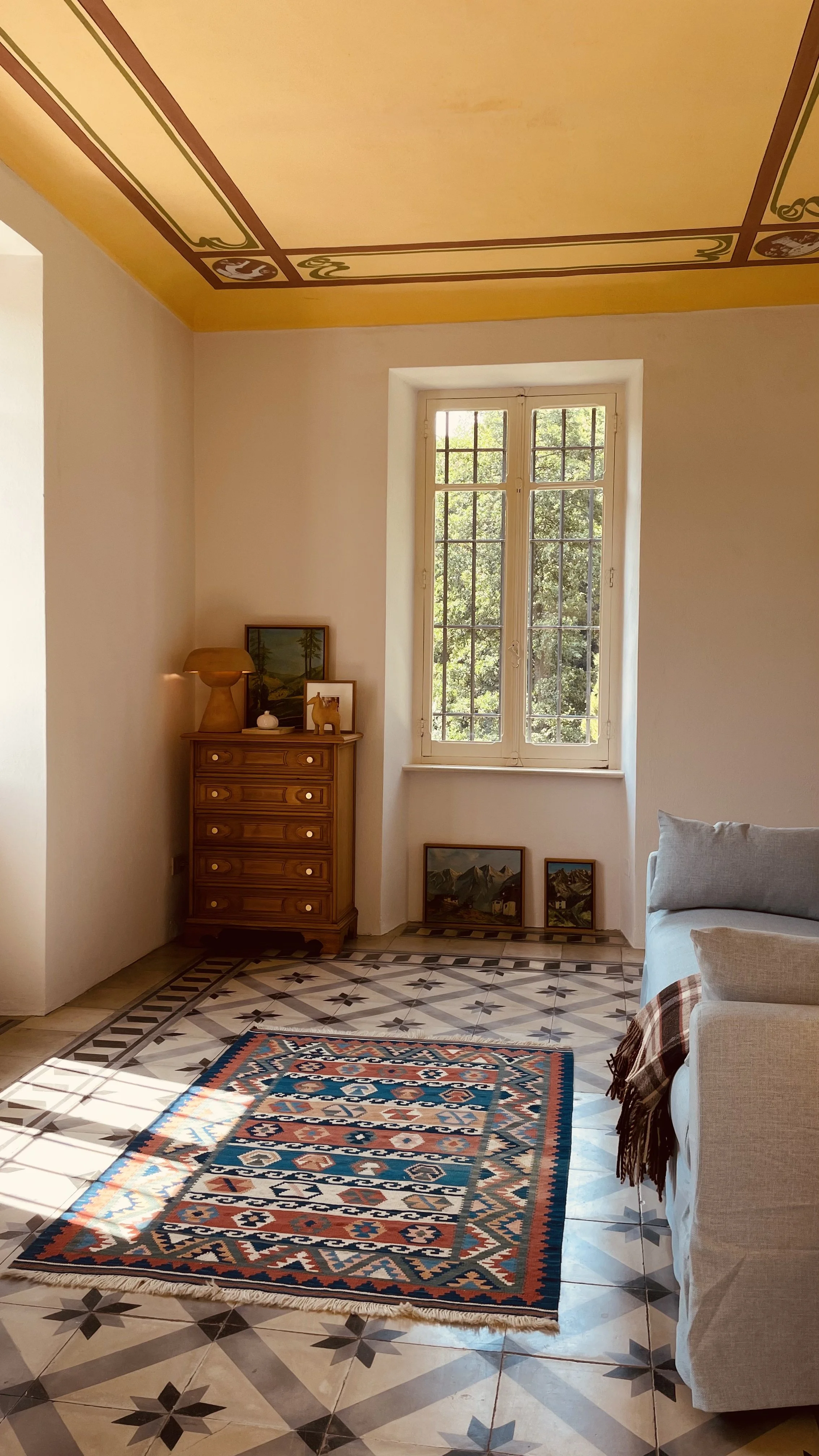 Sunlit study with antique chest, kilim rug and frescoed ceiling at Villa Oberti near Mondovì in Piedmont