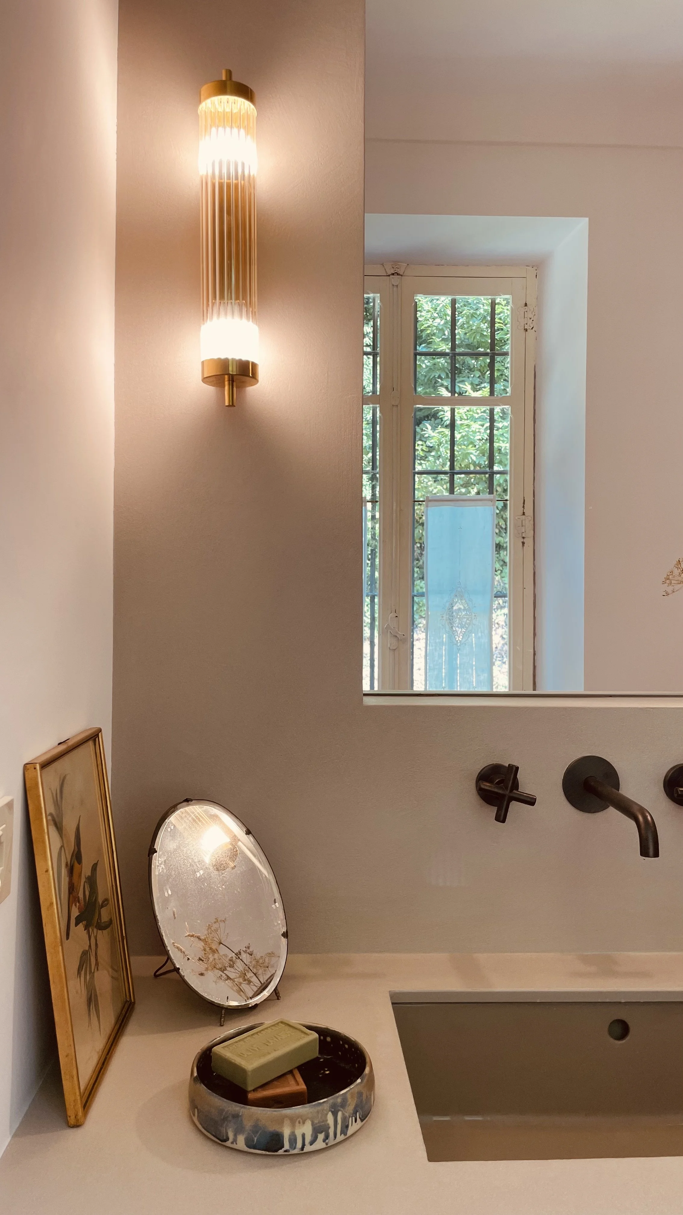 Bathroom basin with botanical art and garden view at Villa Oberti, a charming countryside villa in Piedmont