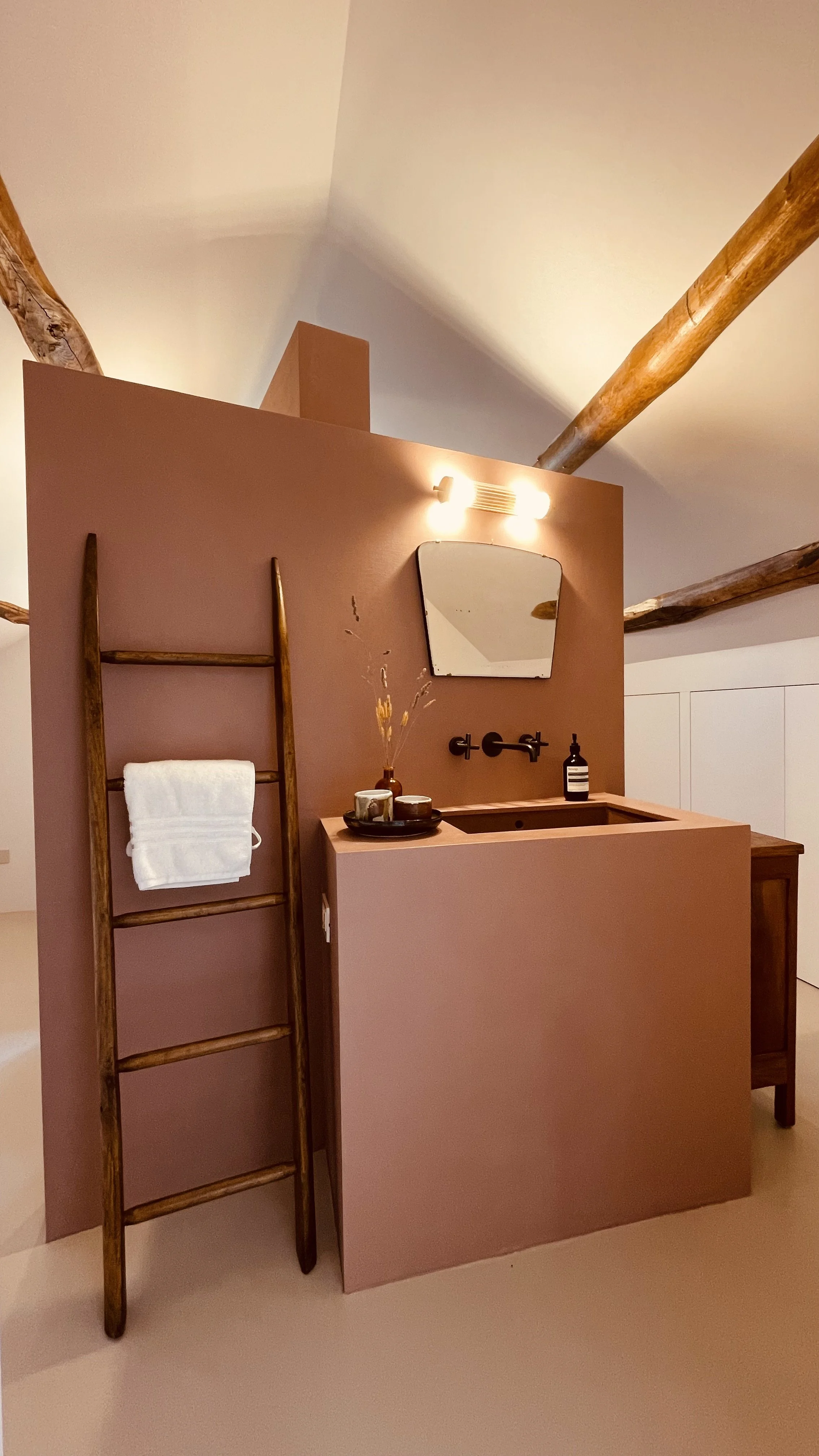 Design bathroom with terracotta resin and exposed beams in the Cielo Suite at Villa Oberti in Piedmont