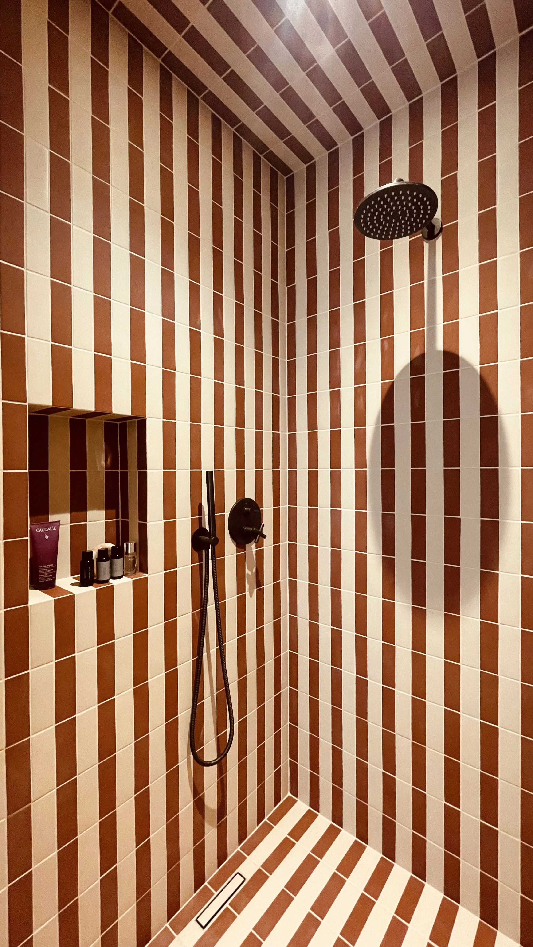Terracotta and cream tiled shower in the Fresco Rooms at Villa Oberti, a restored historic villa in Piedmont