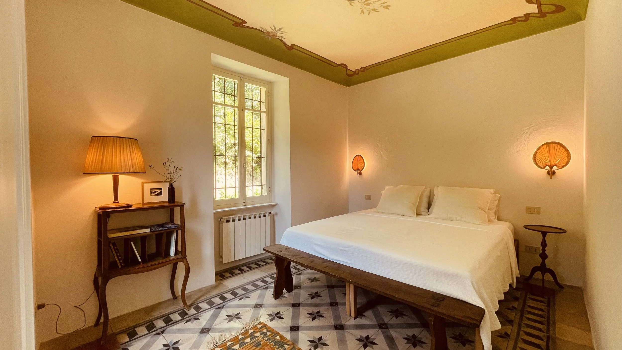Bright double bedroom at Villa Oberti with frescoed ceiling border and garden view, in a charming private villa in Piedmont