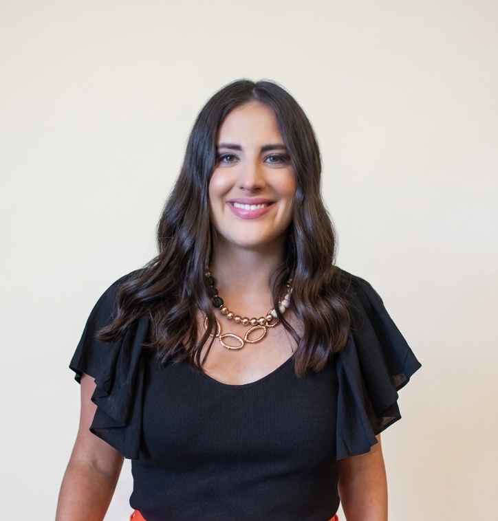 Professional headshot of Rita Childers, a certified developmental editor based in St. Louis, smiling with long brown hair and a black top.