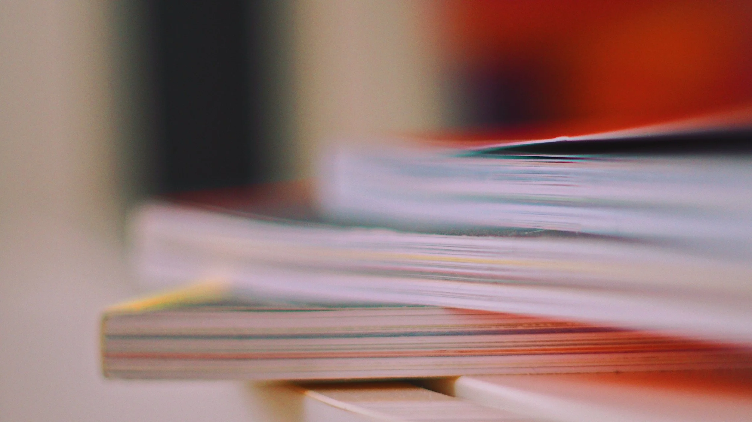 A set of three books stacked on top of one another with a blurred background