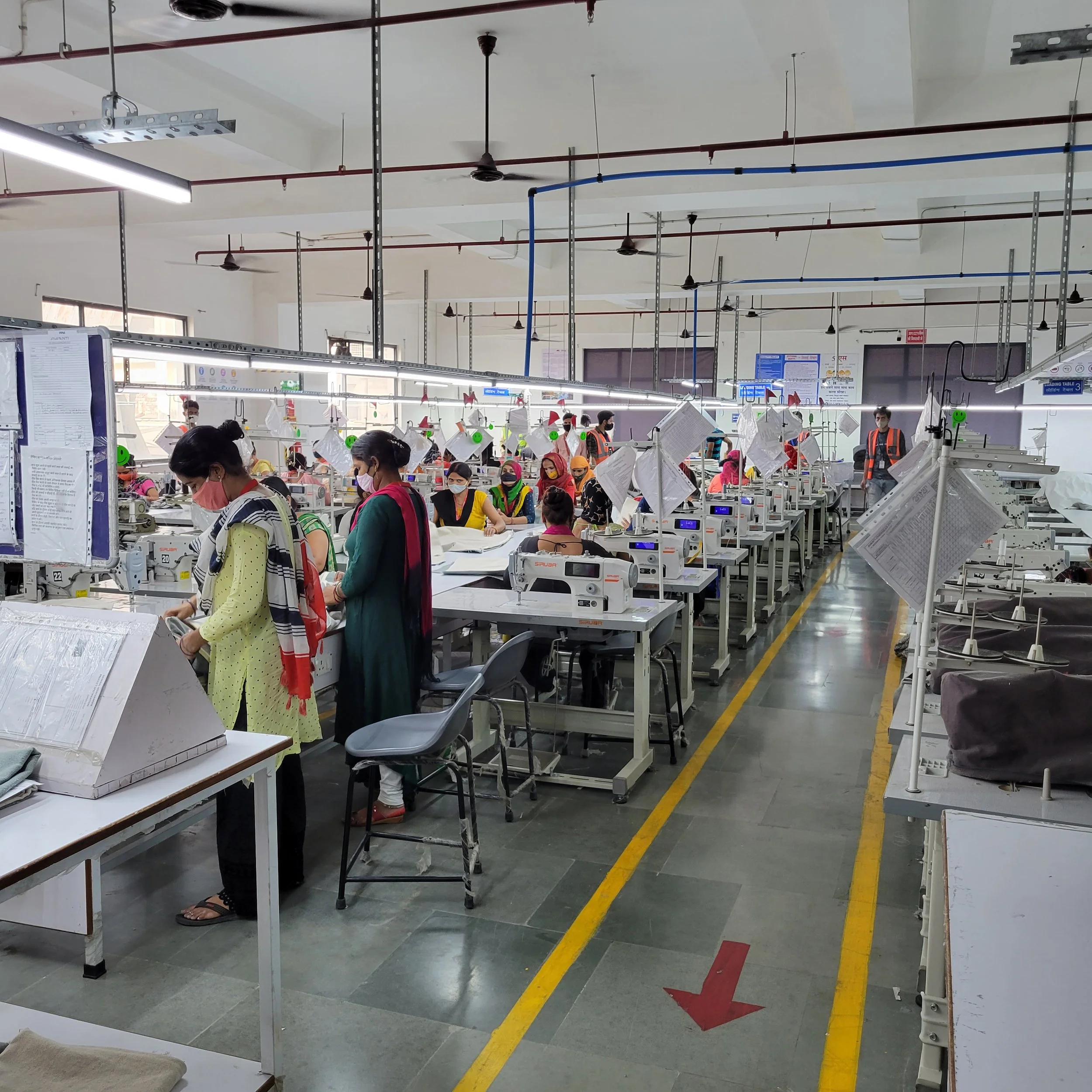 Workers in a factory or workshop managing sewing machines.