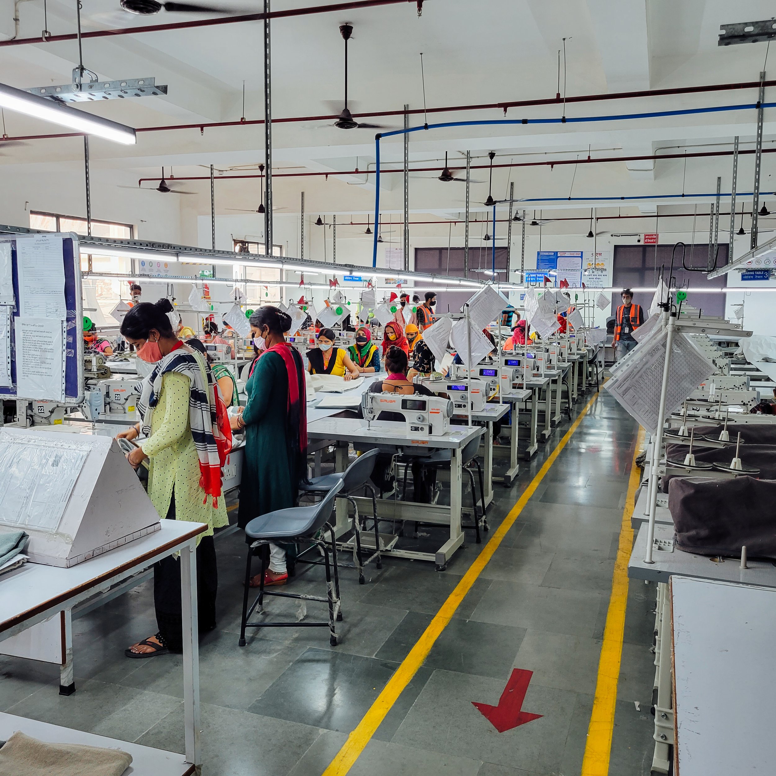 Workers in a factory or workshop managing sewing machines.