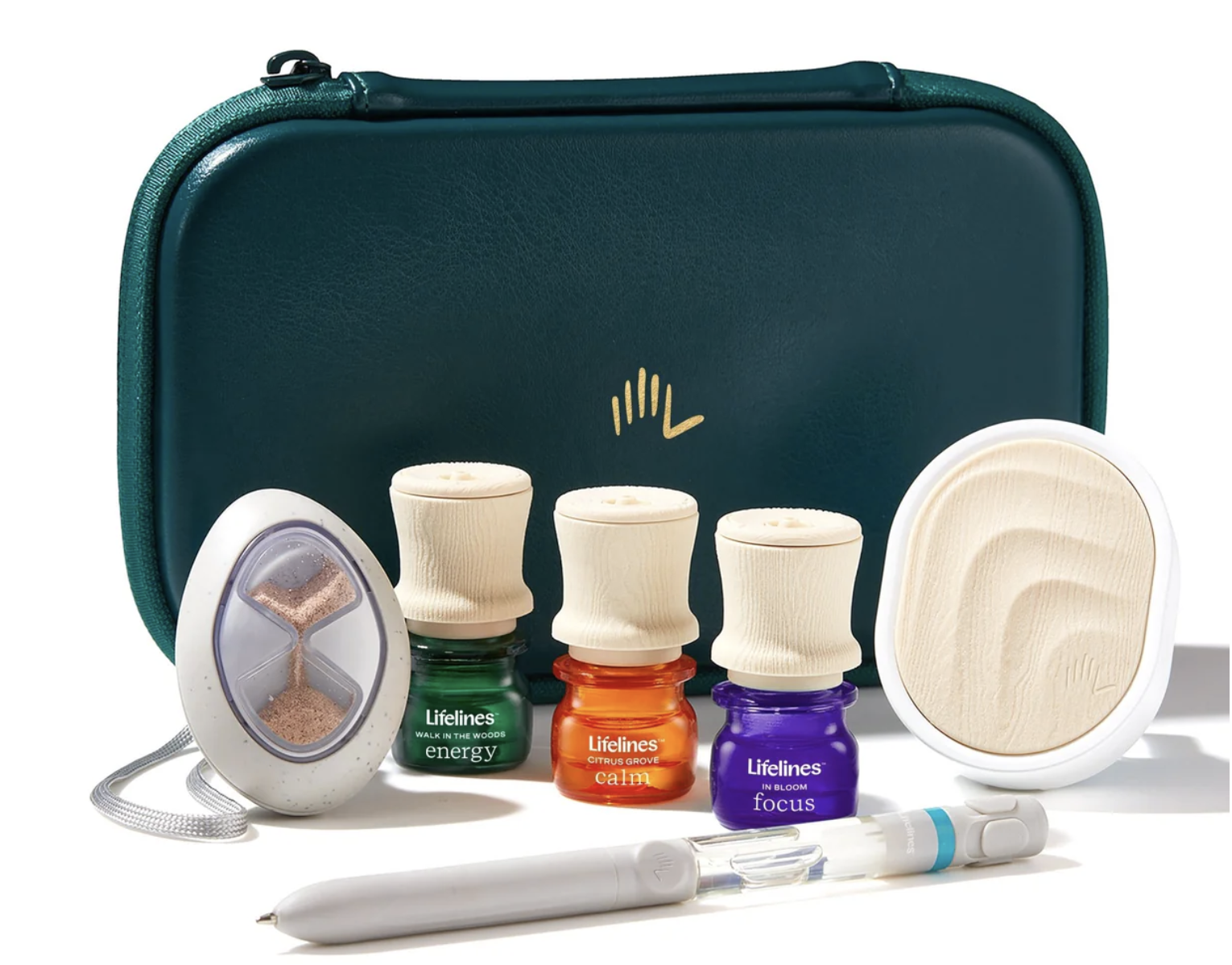 A teal carrying case with a gold logo, and three essential oil bottles labeled energy, calm, and focus, along with a nasal spray, a white handheld device, a white device with a transparent tip, and a small round wooden disc.