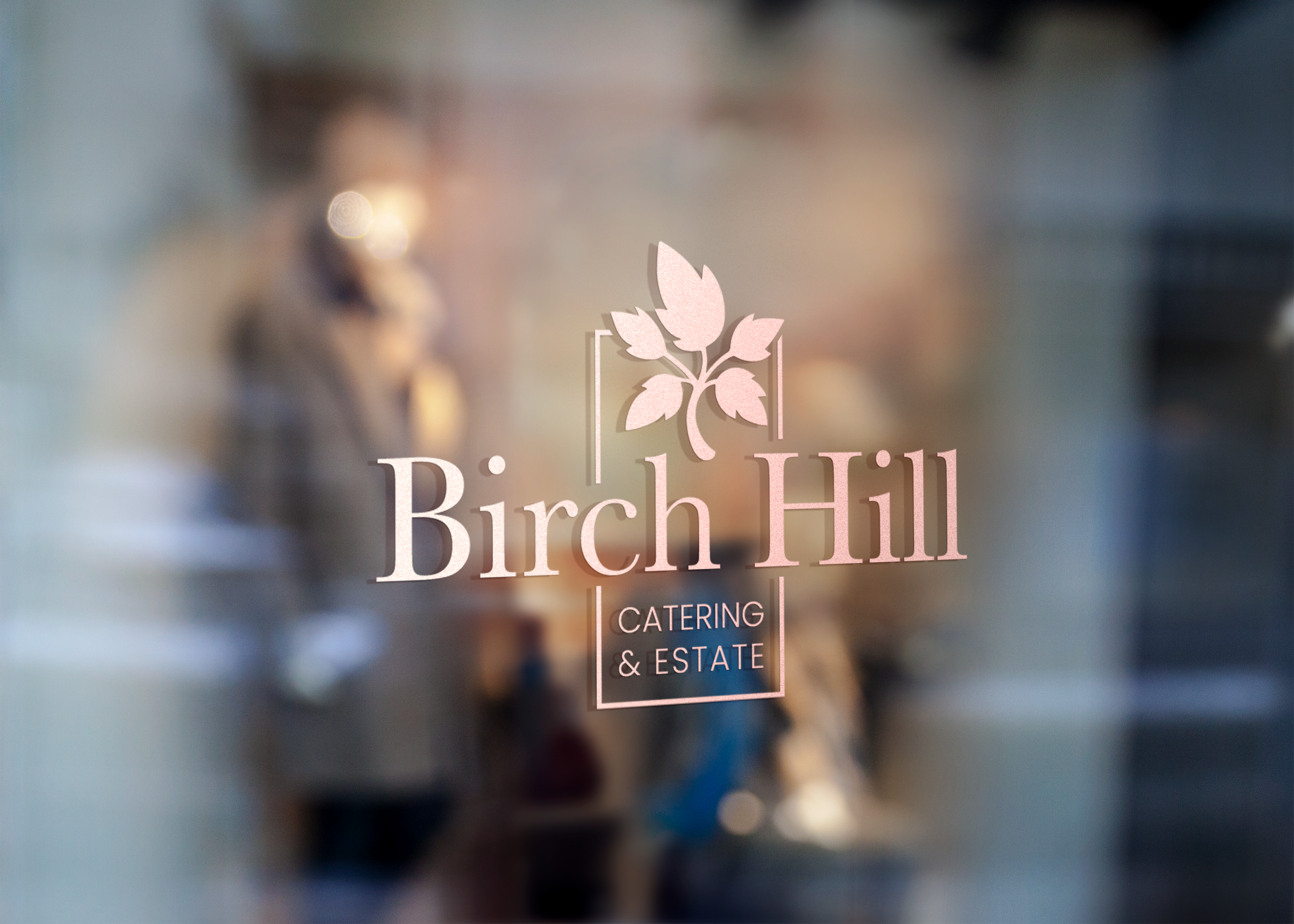 Blurred image of a sign or logo for Birch Hill Catering & Estate, featuring a pink silhouette of a birch leaf and stem.