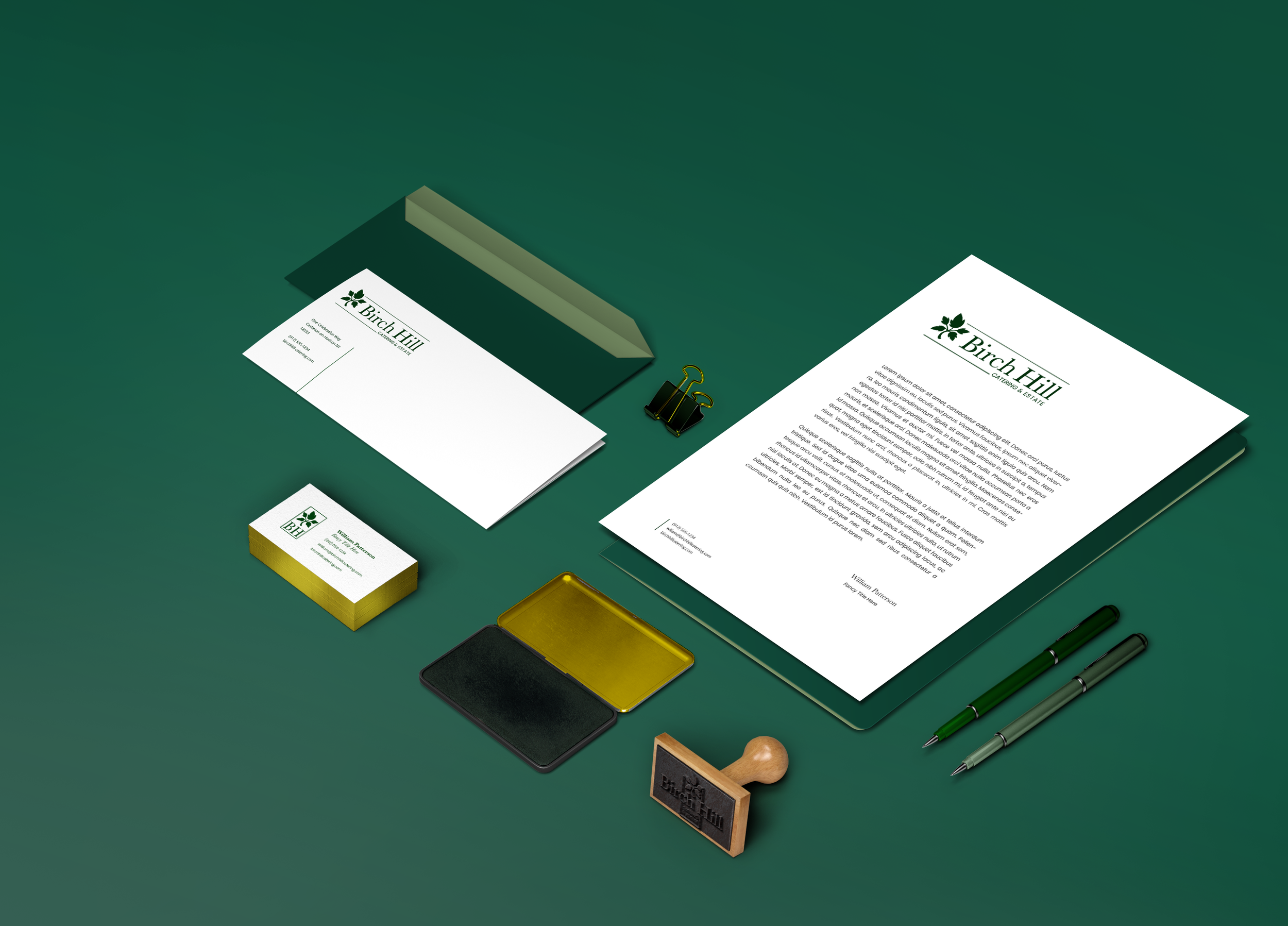 Business stationery and office supplies on a green surface, including letterheads, business cards, clips, and pens, all branded with Birch Hill logo and design.