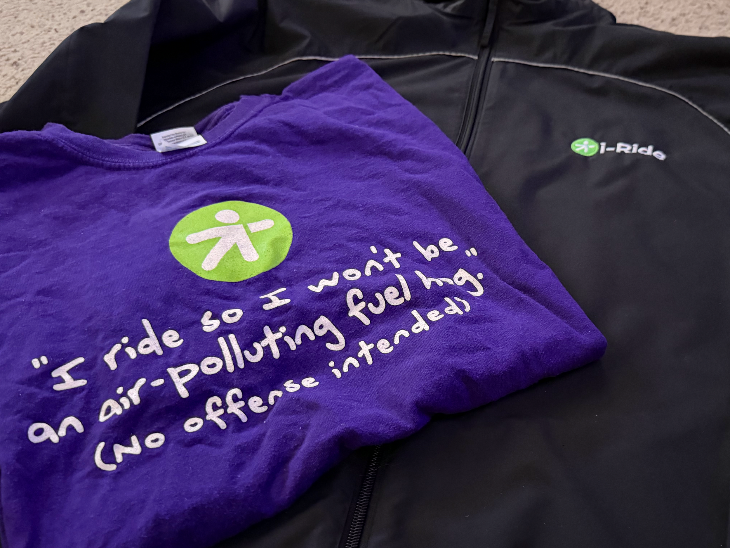 i-Ride and "Dump the Pump" side-by-side on staff gear, not just bus wraps. Two campaigns, one message: leave the car, take the bus.

