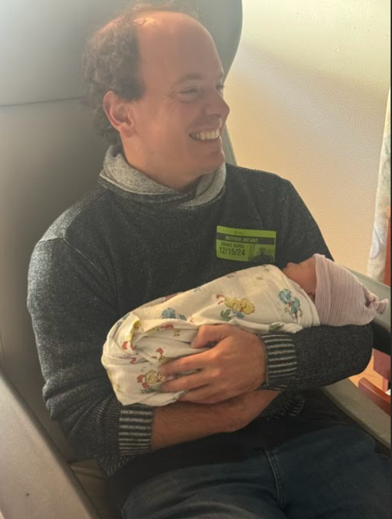 Drake Burd holding a newborn family member in a Santa Ynez hospital.