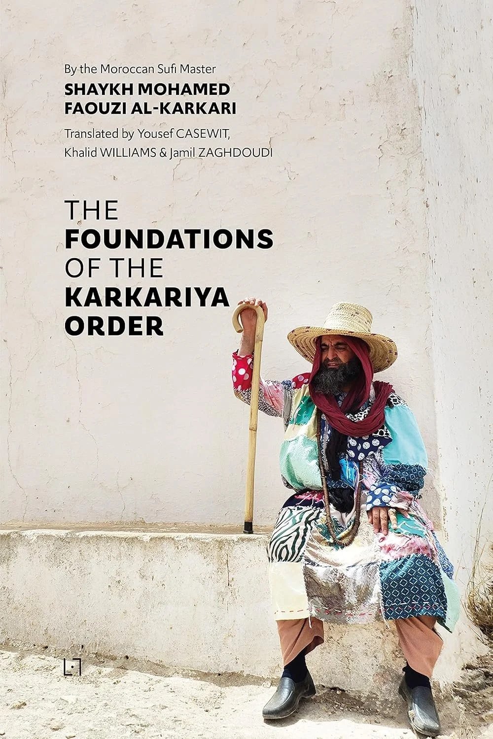 Book cover titled "The Foundations of the Karkariya Order" by Sheikh Mohamed Faouzi Al-Karkari, featuring a man in traditional attire with a straw hat, colorful clothing, a red headscarf, and a walking stick, sitting against a plain wall.