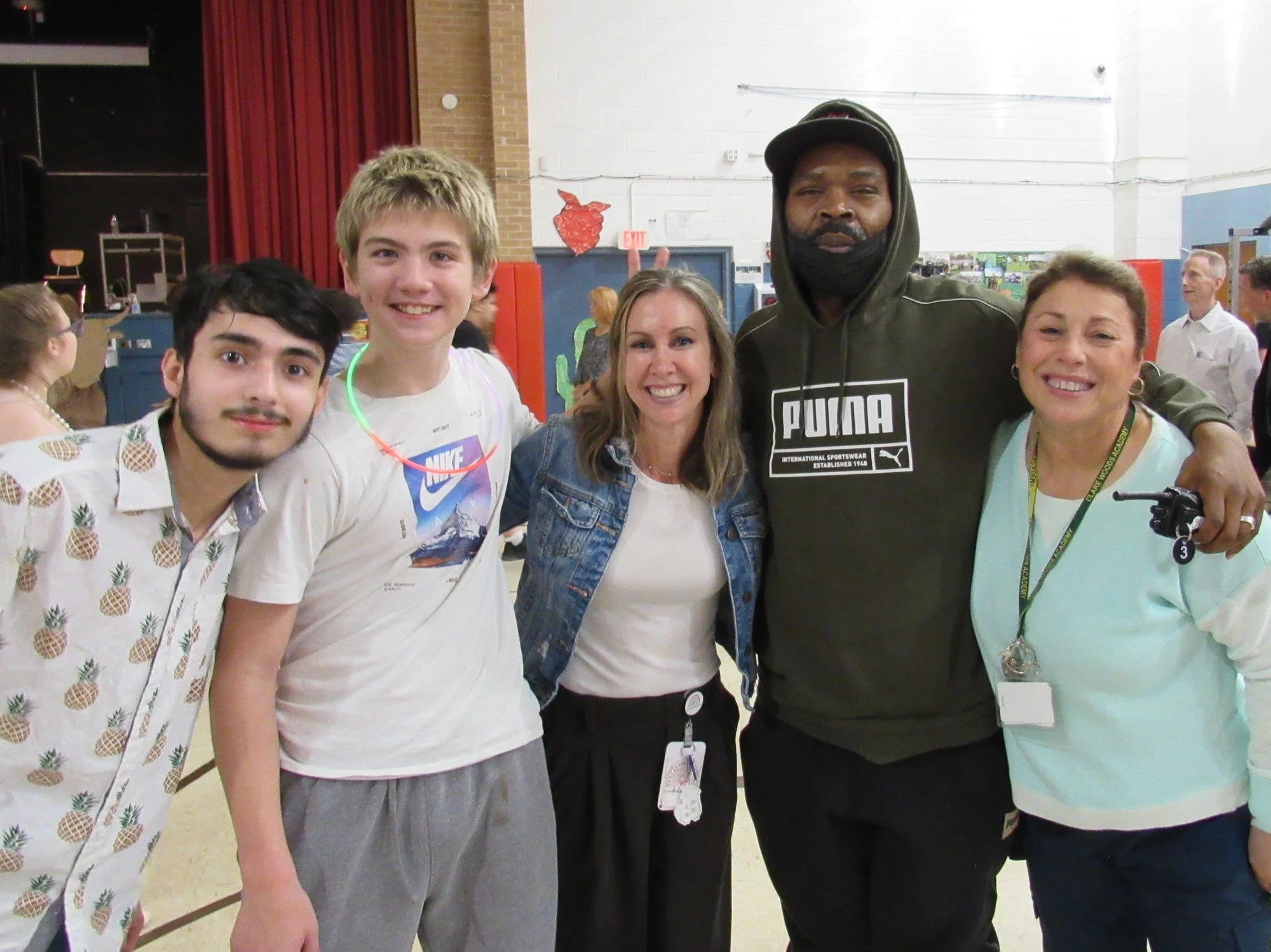 Staff and students pose together in a gymnasium