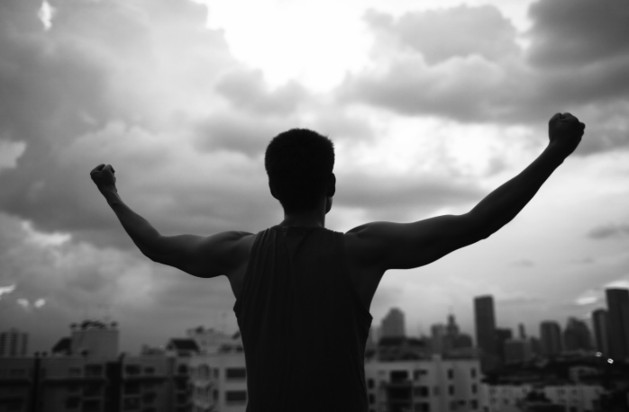 Man with arms outreached appearing confident and calm following getting grief therapy because he's learned how to control and regulate his emotions