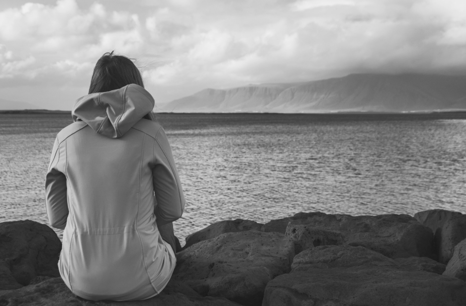 Woman Looking into the ocean thinking about grief, loss, and difficult life transitions