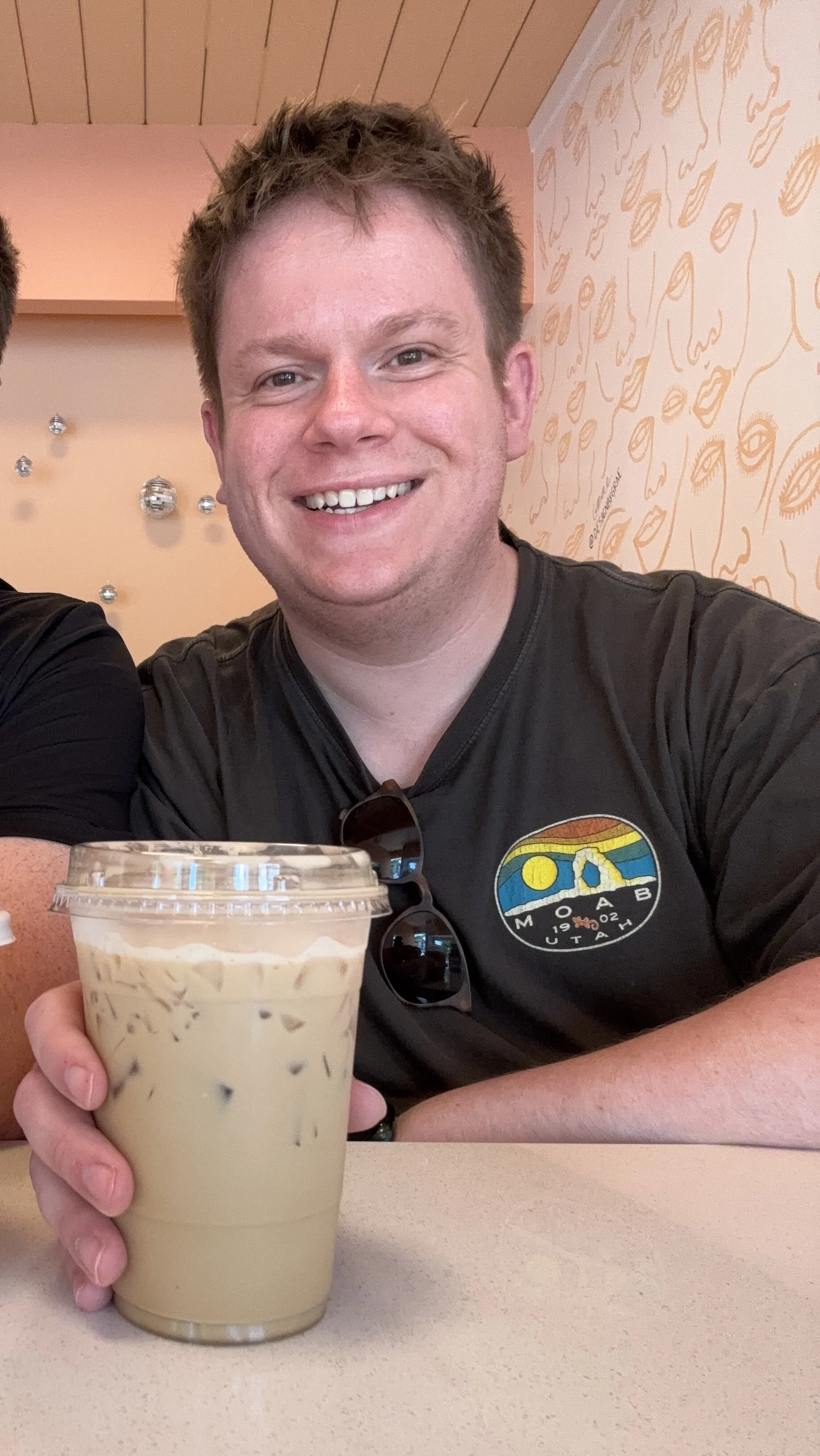 Jordan Crosby, grief therapist based in west seattle at the west seattle center for grief, loss, and transition drinking a coffee at Lula Coffee in West Seattle