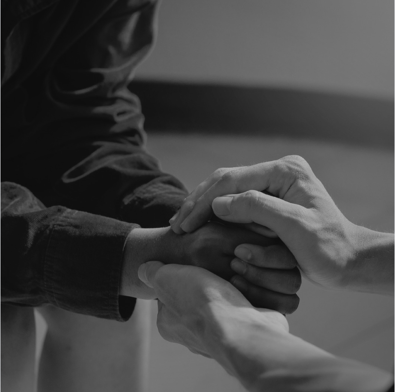 Two hands holding one another in support following a loss in grief