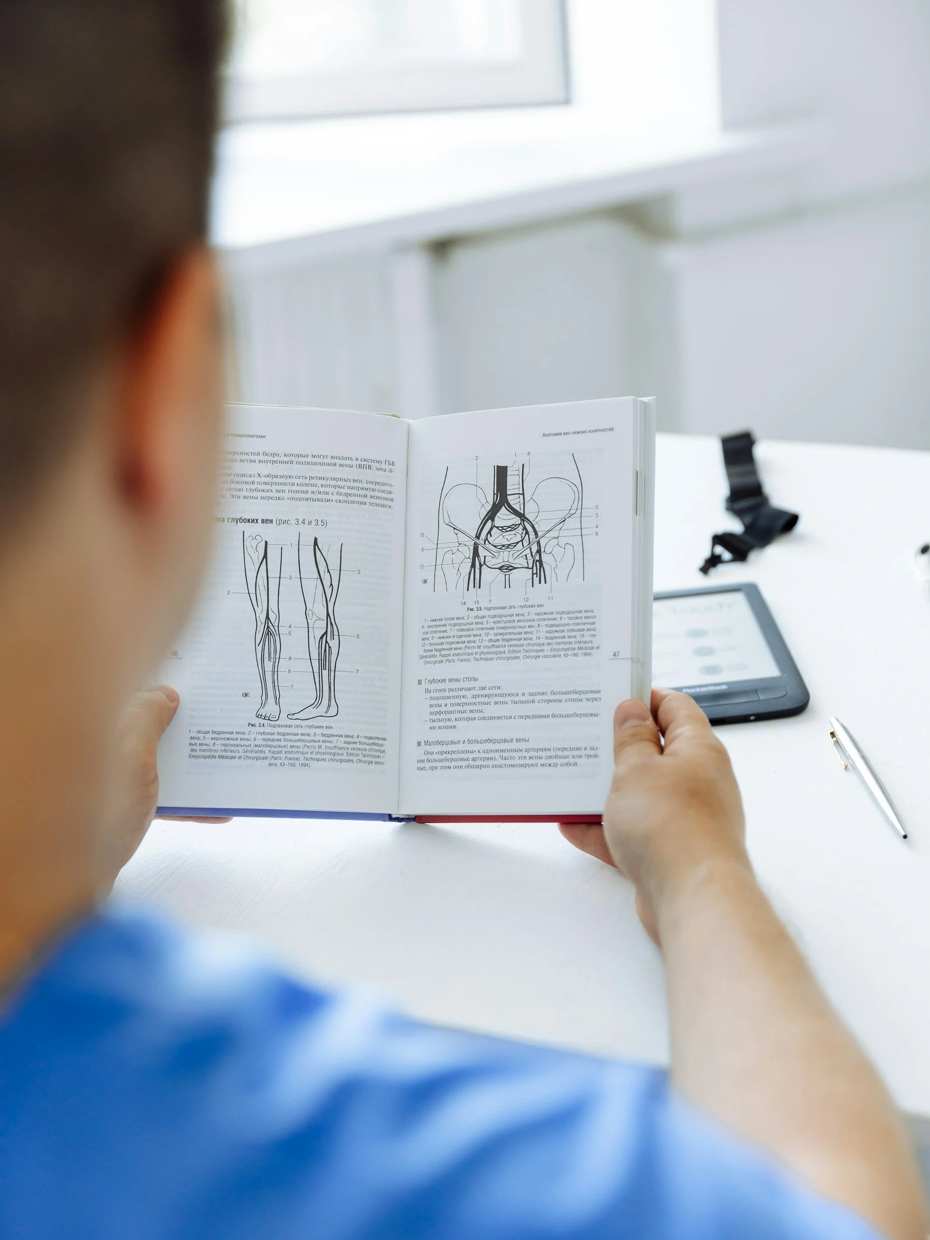 A photo of a man reading a medical book.