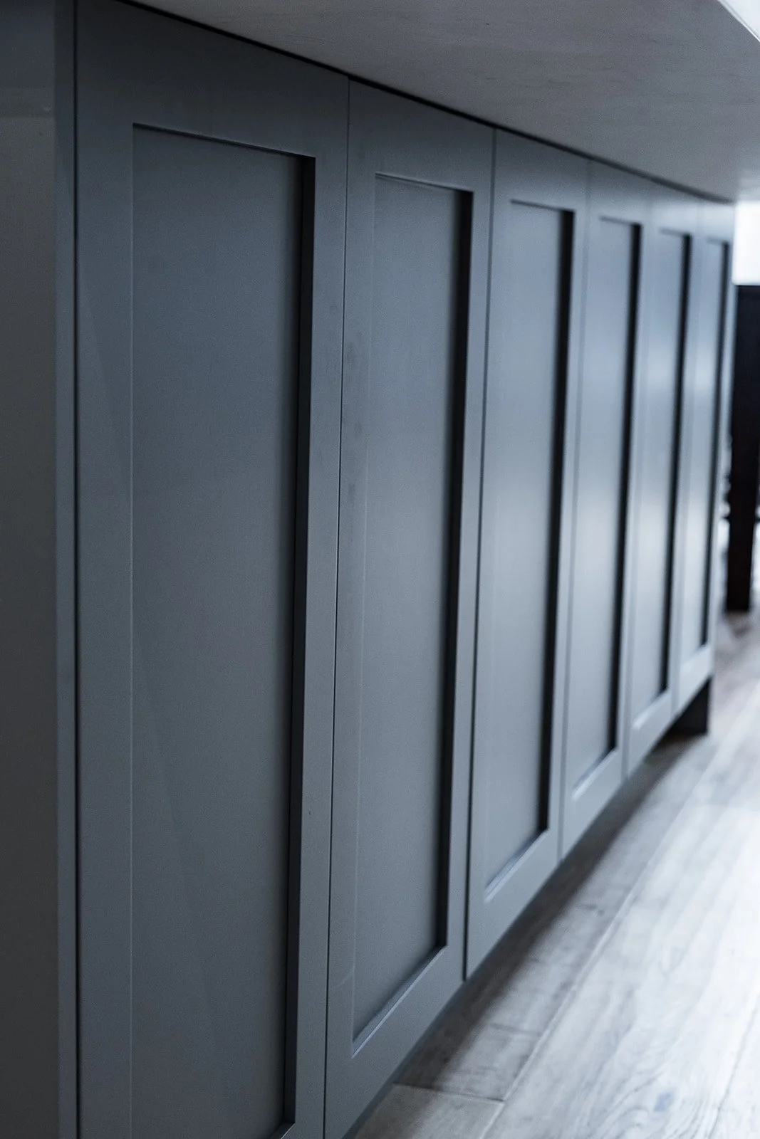 Gray cabinet with multiple doors in a modern interior.