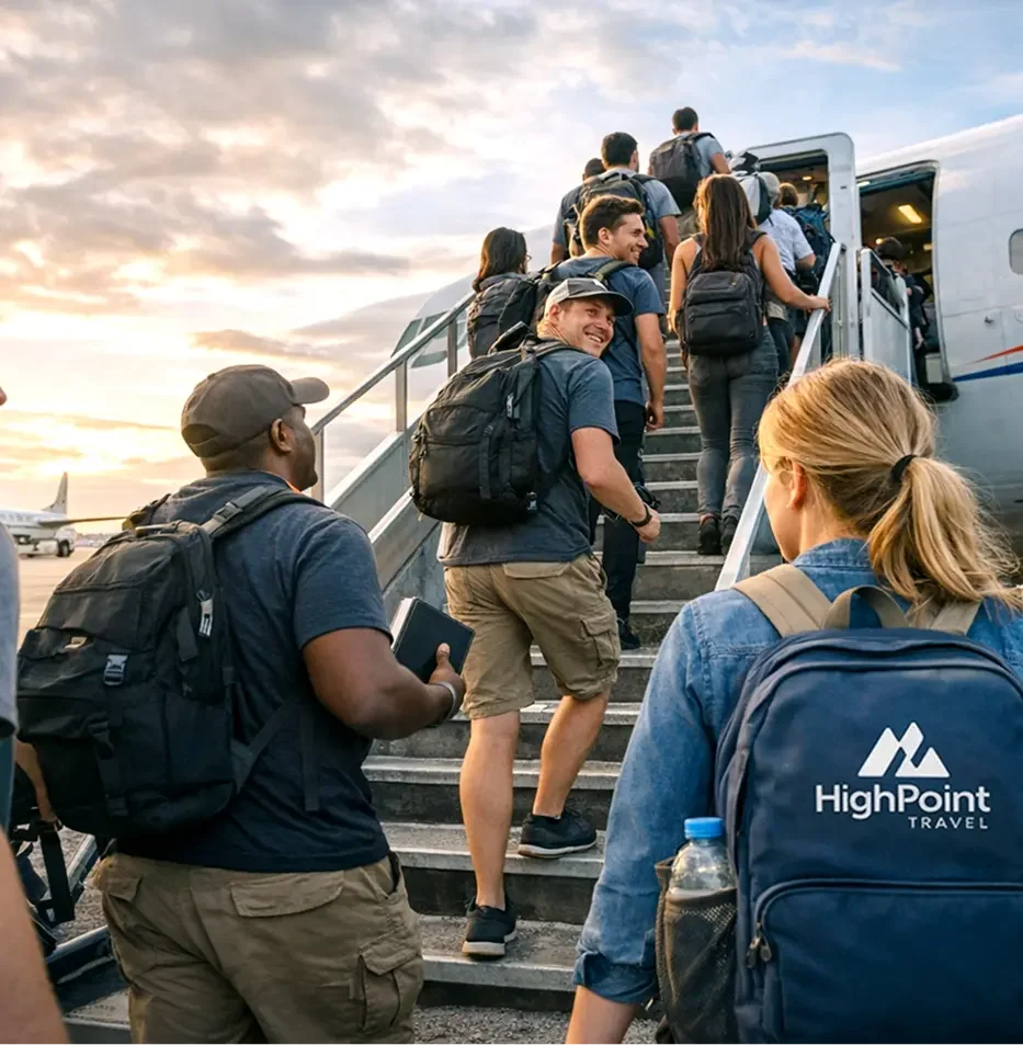 People boarding a plane at an airport with a sunset in the background, many wearing backpacks and travel gear.