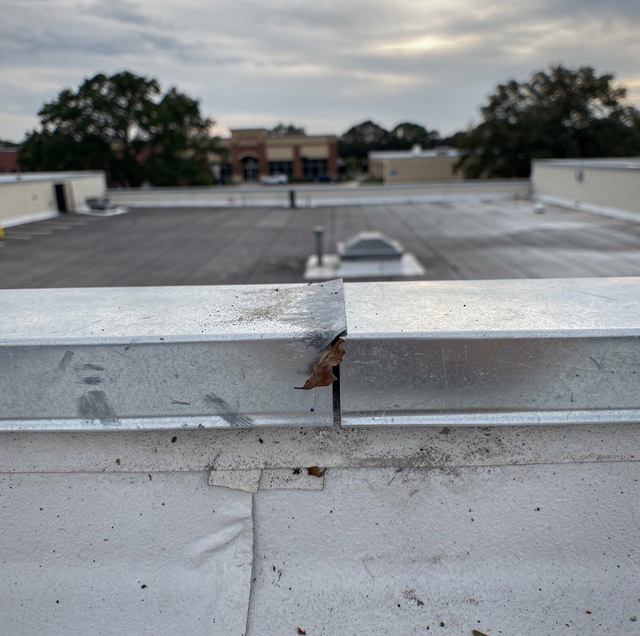 Weathered membrane on low-slope commercial roof with ponding water