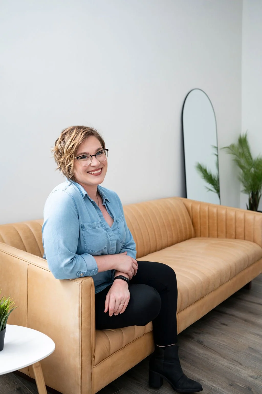Business coach Chelsey Hart sitting on a sofa in a coaching space, providing one-to-one business coaching and entrepreneurship support for small business owners and professionals.